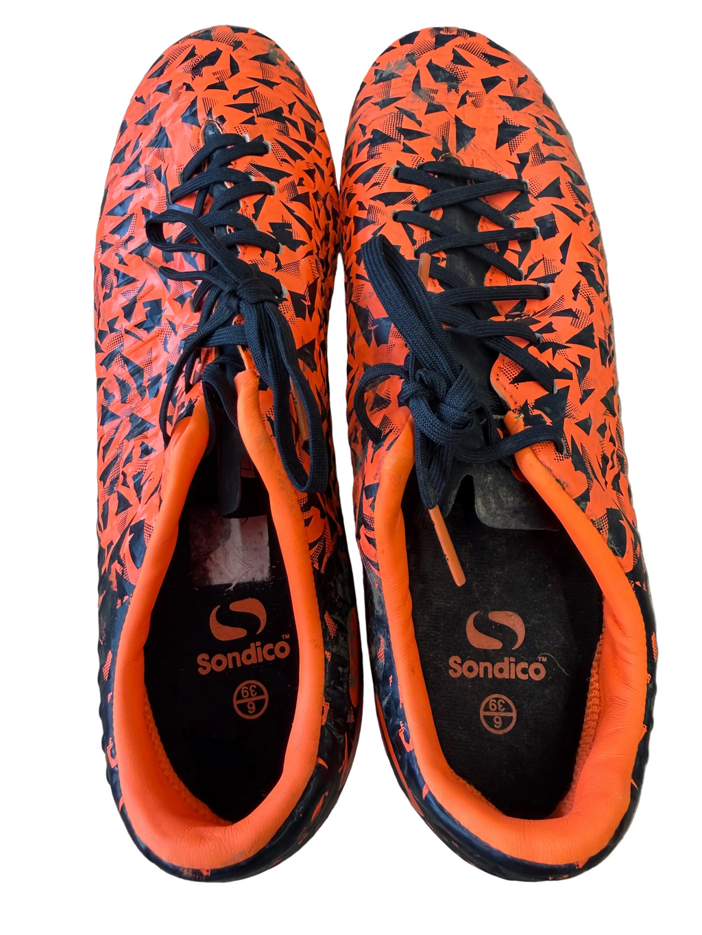 Pair of Sondico Blaze football boots with black and orange geometric pattern, top view