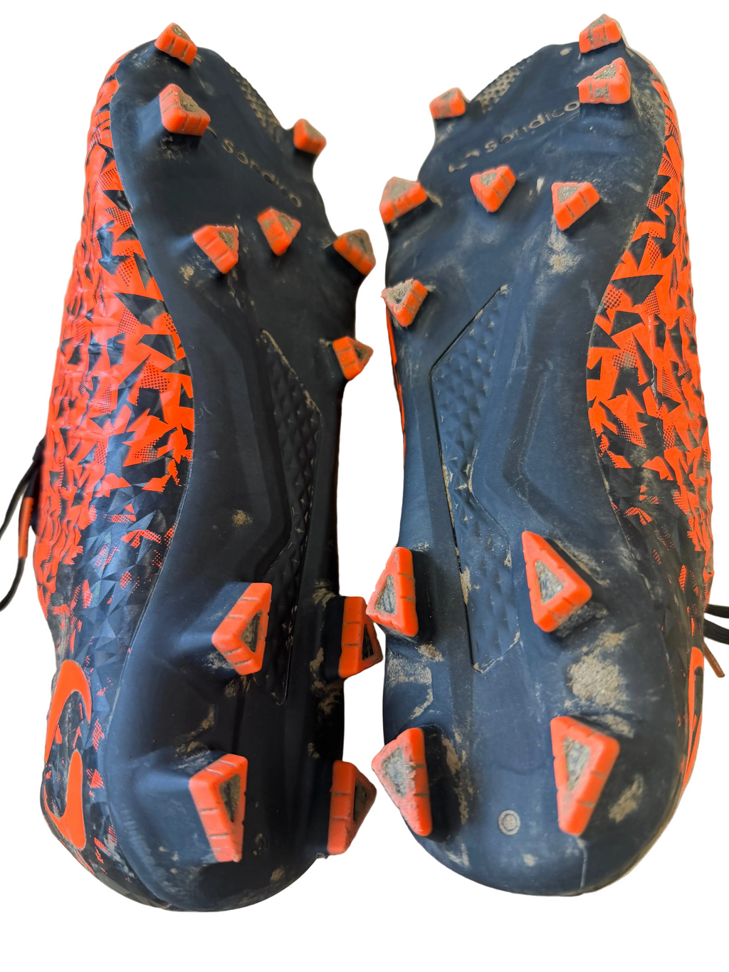 Outsoles of Sondico Blaze football boots highlighting orange and black moulded studs