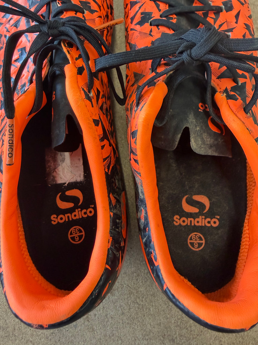 Close-up of Sondico Blaze football boots showing orange lining and lace-up detail