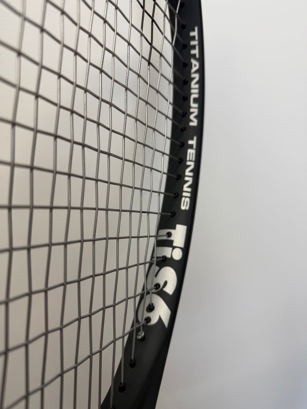 Angle view of HEAD Ti.S6 racket with 'Titanium Tennis' and string detail