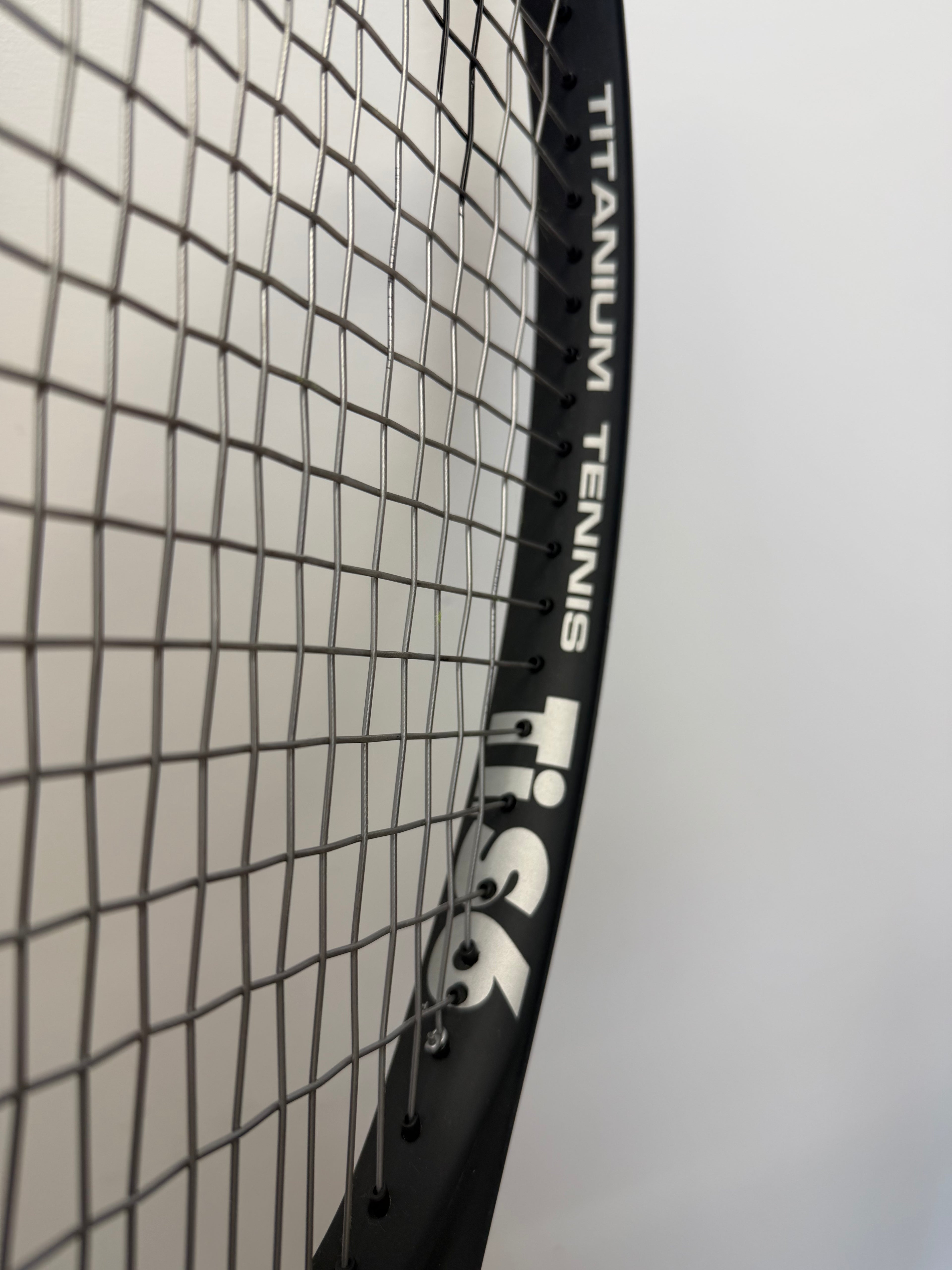Angle view of HEAD Ti.S6 racket with 'Titanium Tennis' and string detail