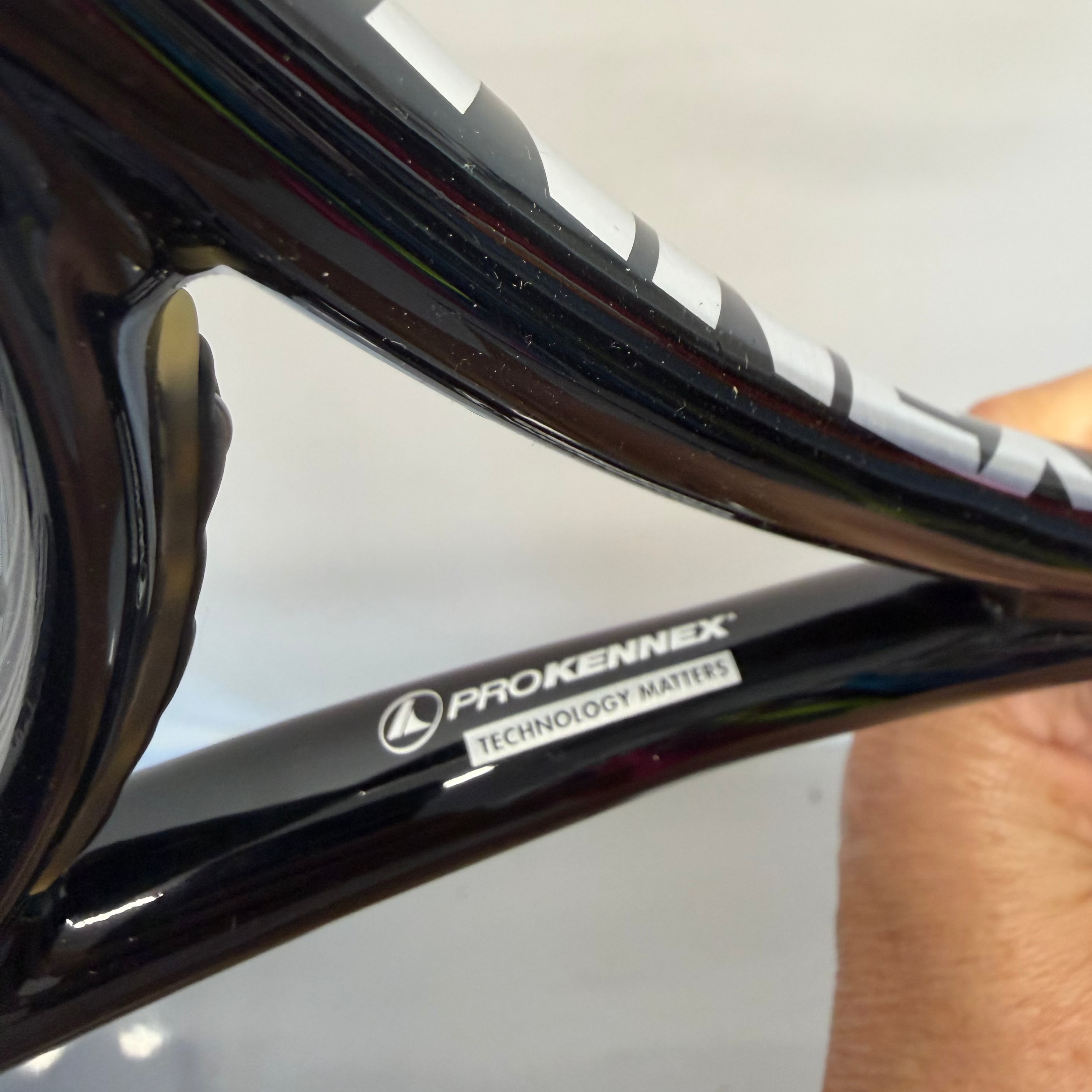 Close-up of ProKennex brand and Technology Matters printed on tennis racket throat