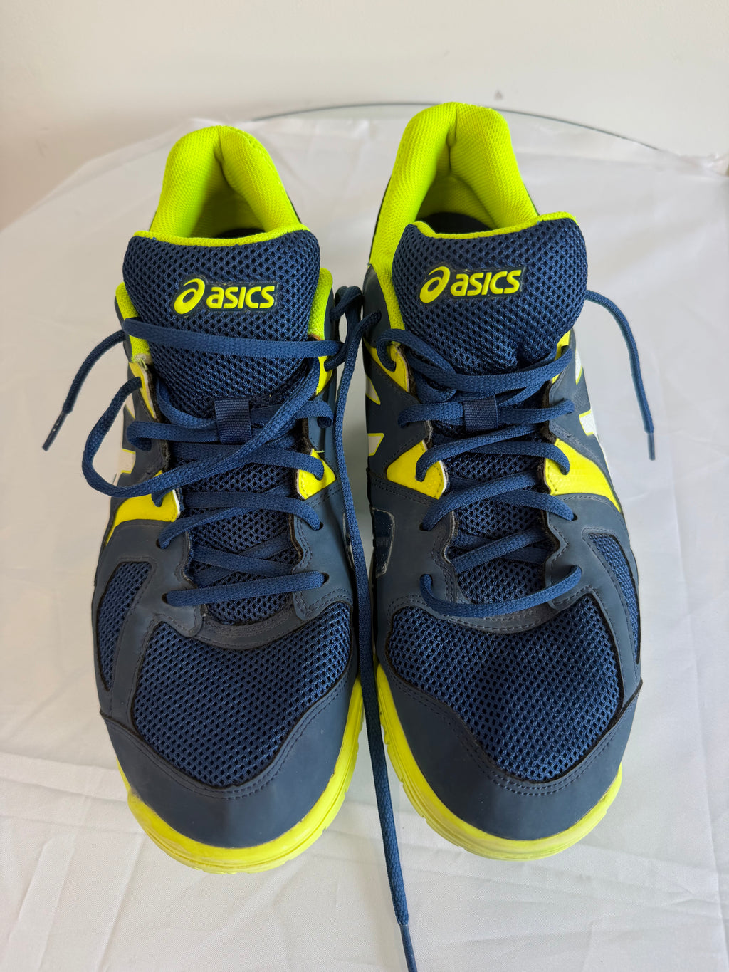 Pair of ASICS navy and yellow sports trainers viewed from above