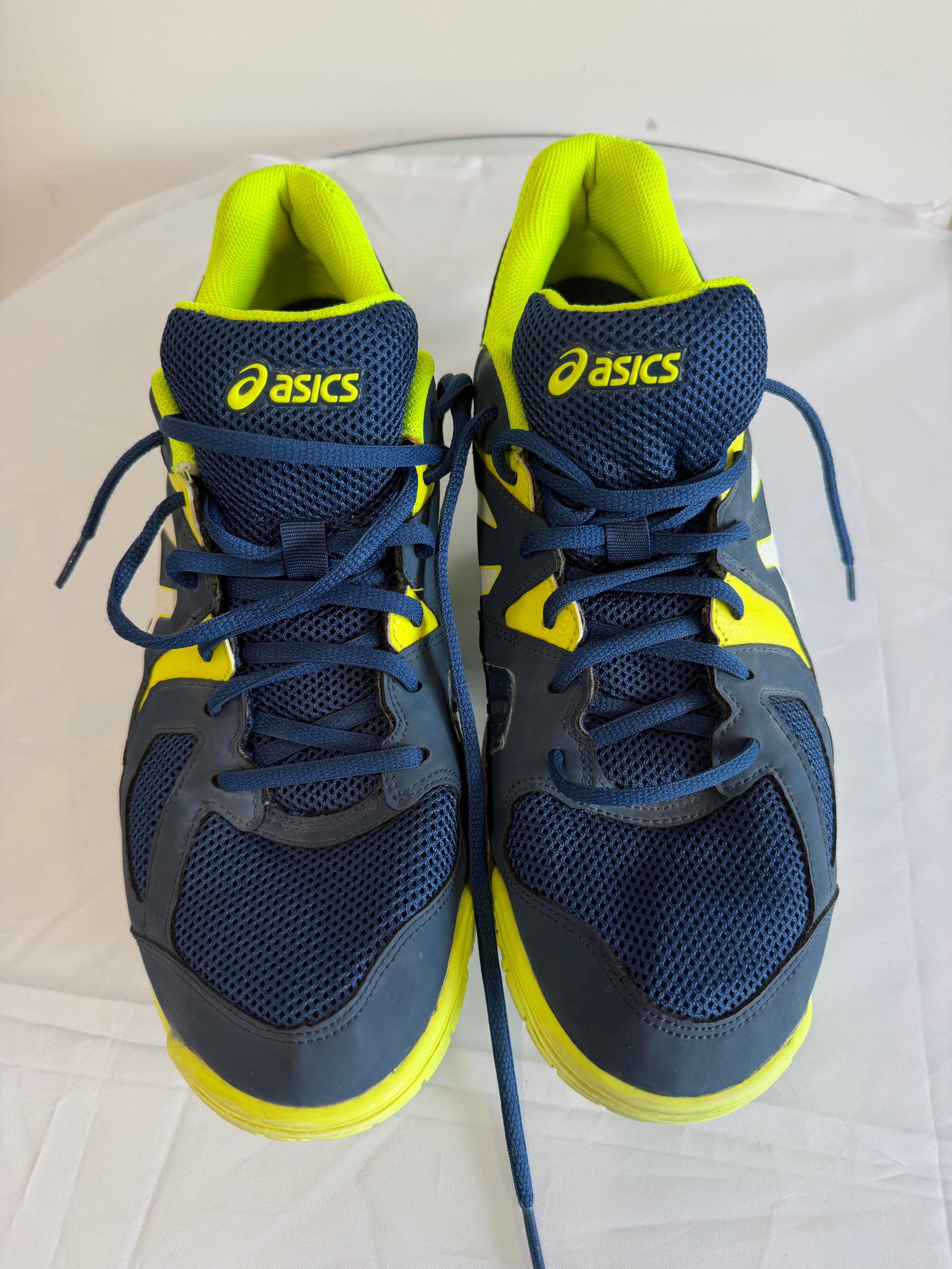 Pair of ASICS navy and yellow sports trainers viewed from above