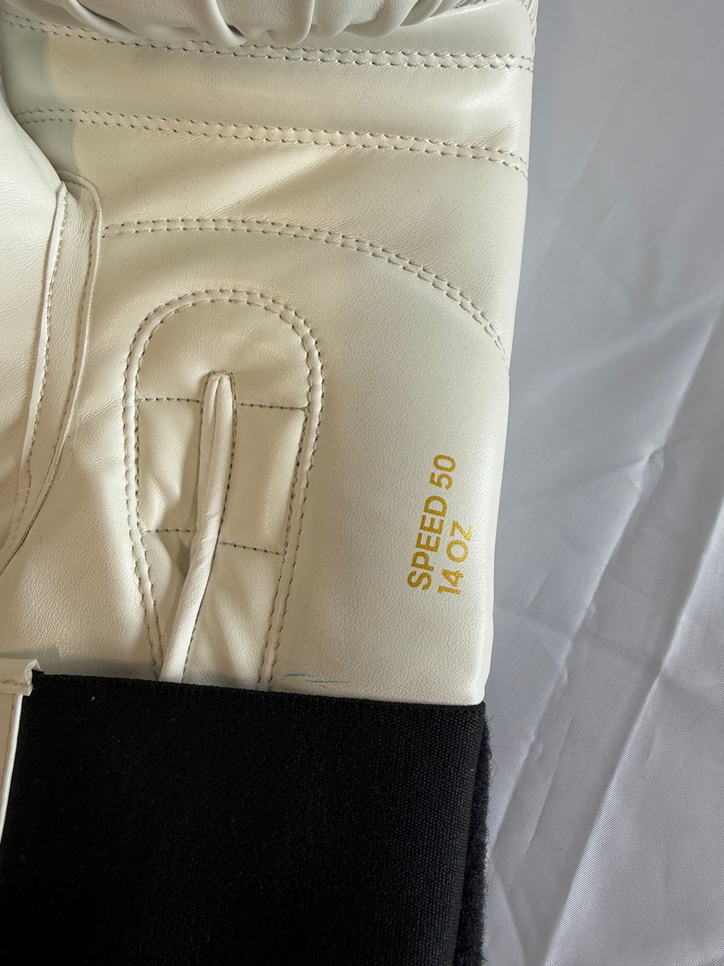 Close-up of adidas boxing glove showing SPEED 50 14 OZ marking and stitching