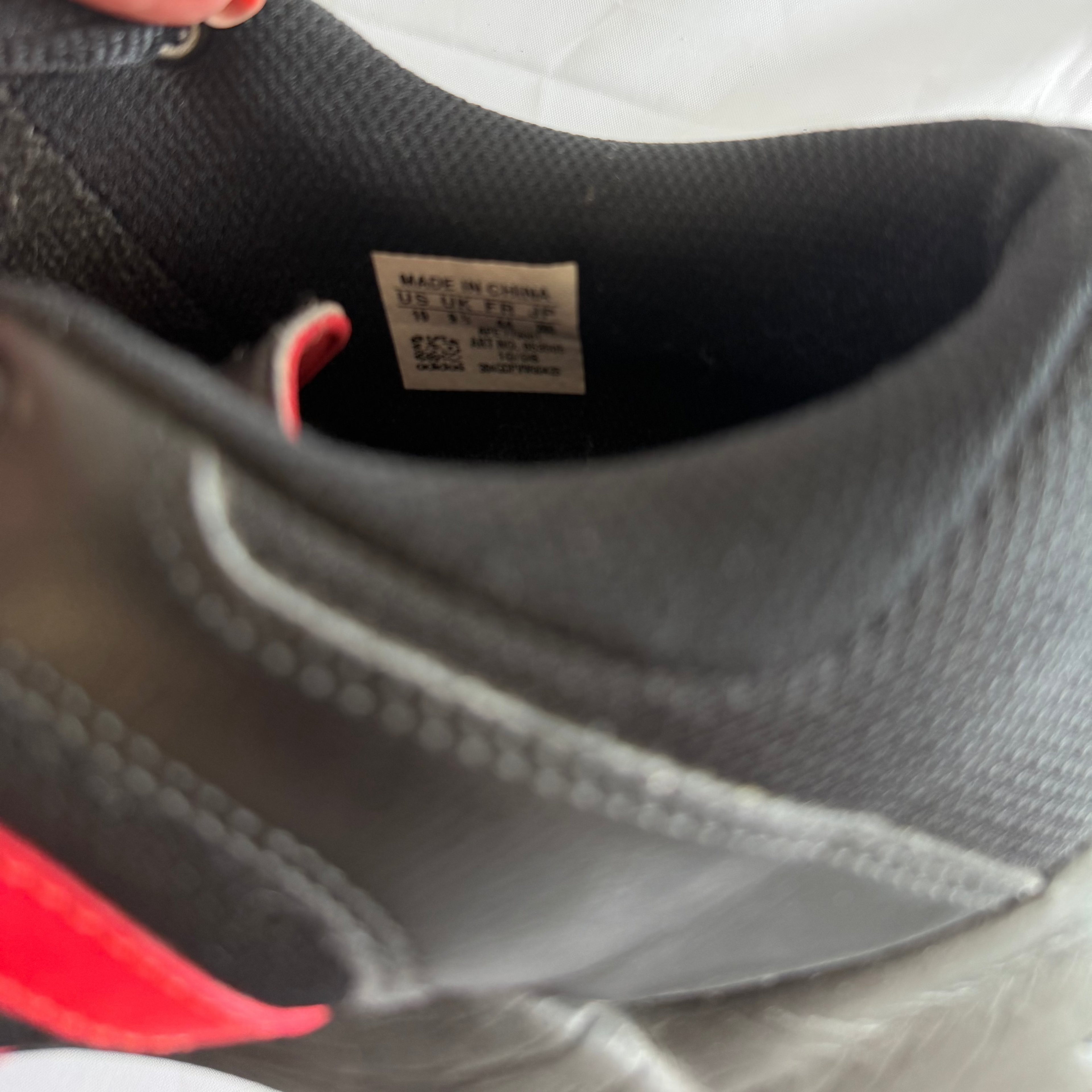 Inner label of Adidas court shoes showing size and manufacturing details