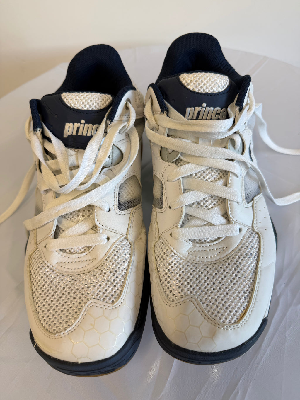 Pair of Prince trainers in white and navy viewed from above
