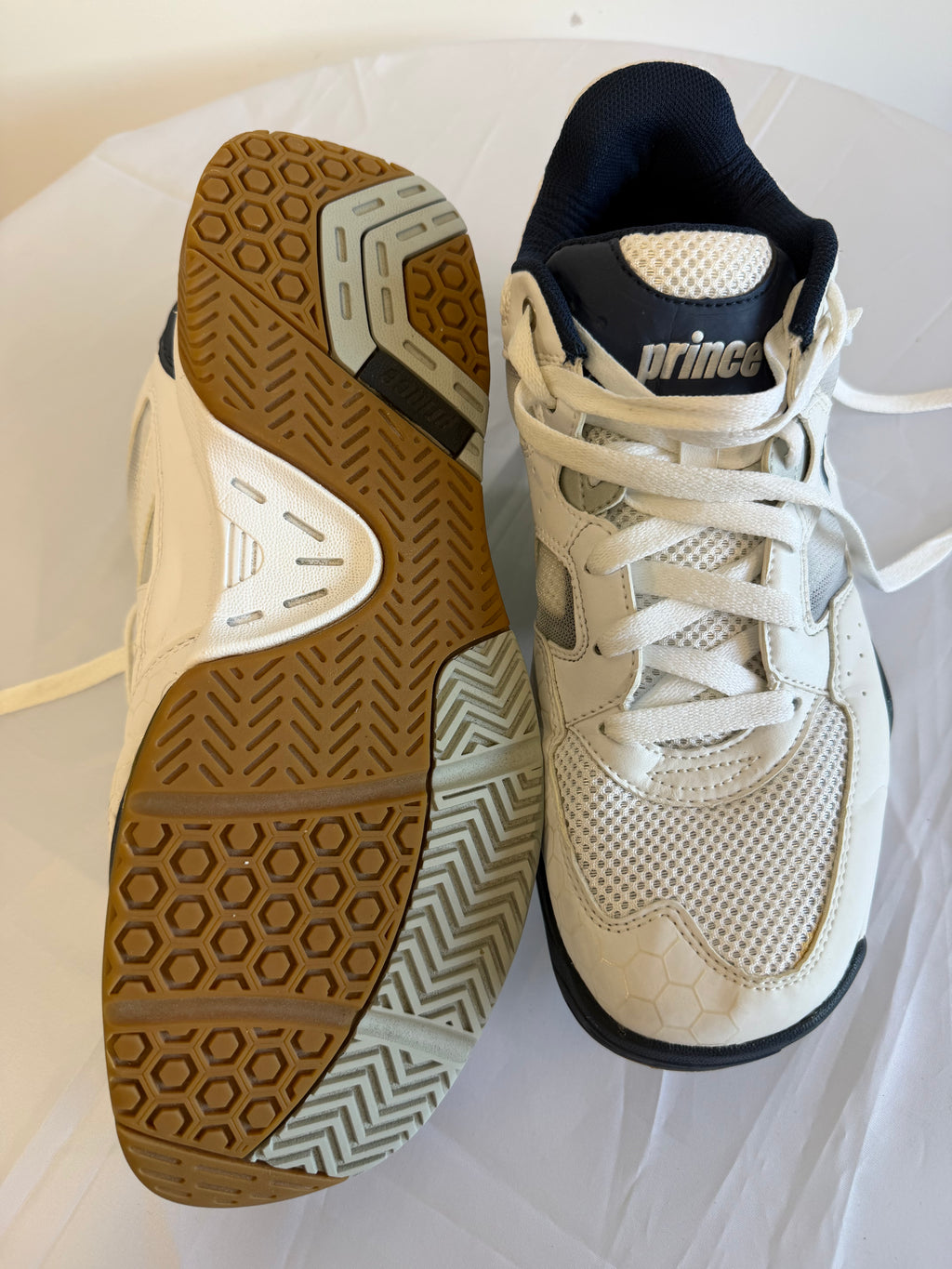 Prince trainers showing top and sole views on a white surface