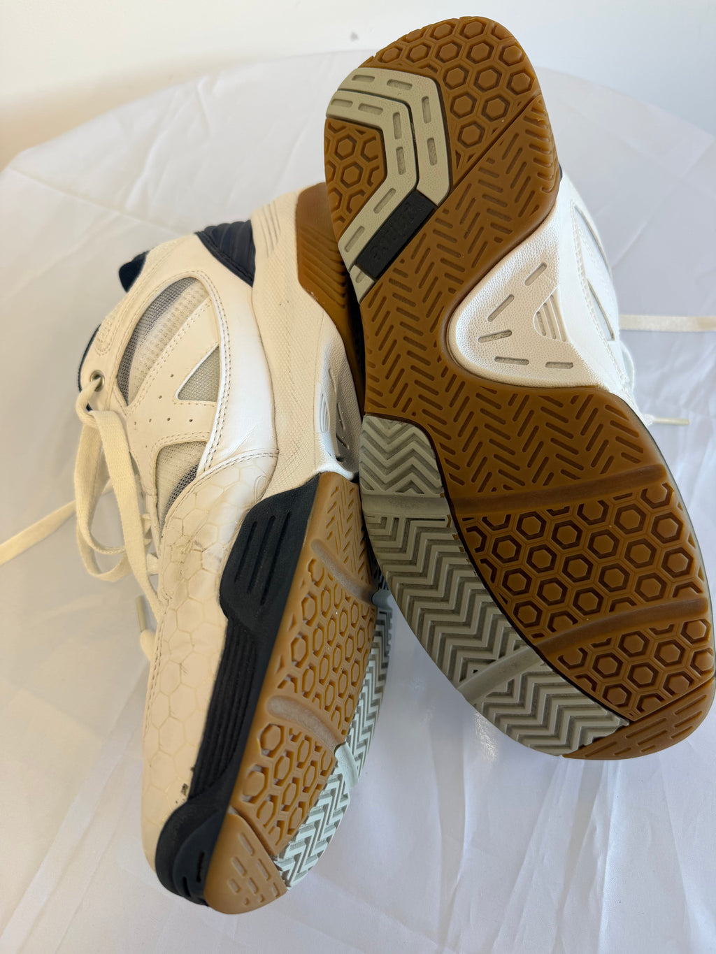 Outsoles of Prince trainers highlighting gum and grey textured grip pattern