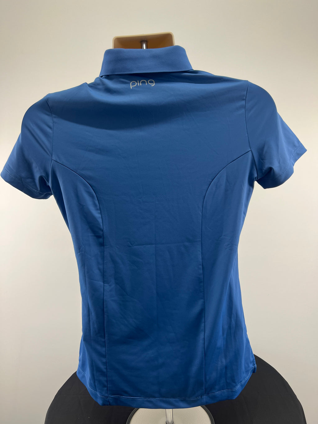 Back view of Women’s Ping Solheim Cup Finca Cortesin blue polo shirt showing Ping logo on collar
