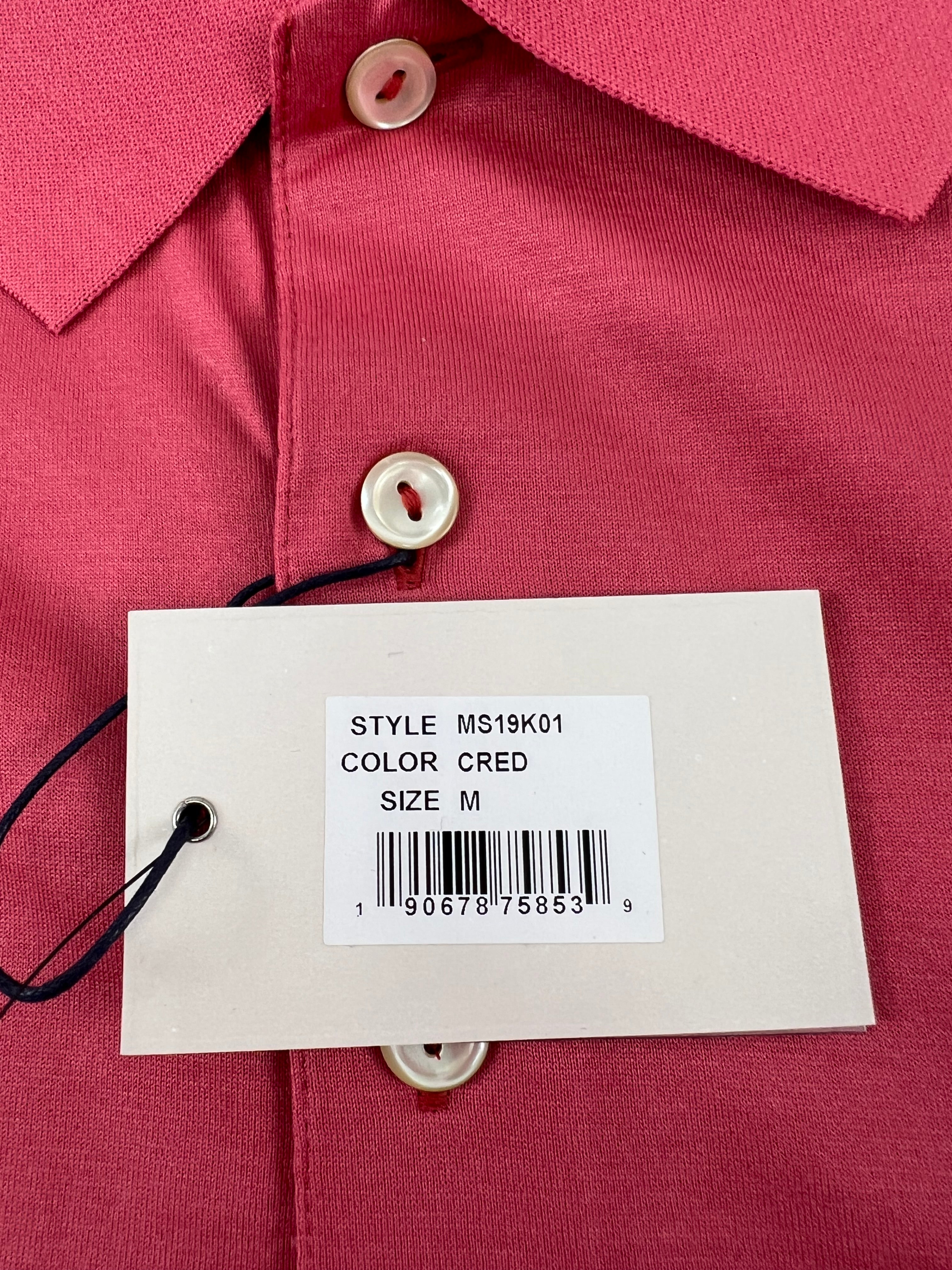 Close-up of tag showing style MS19K01, color CRED, size M on pink Peter Millar polo