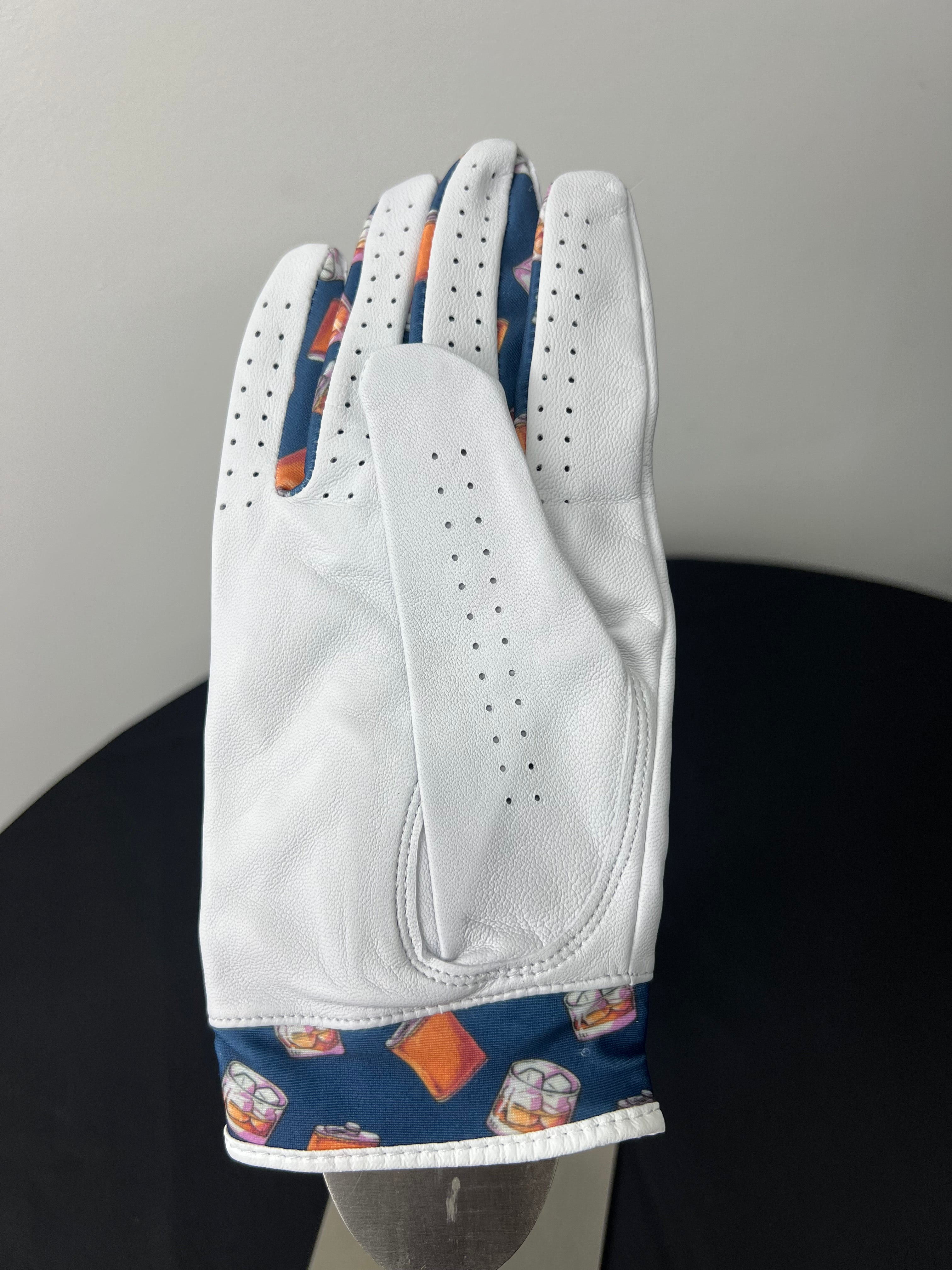 Women's right hand golf glove with whiskey motif trim, back view