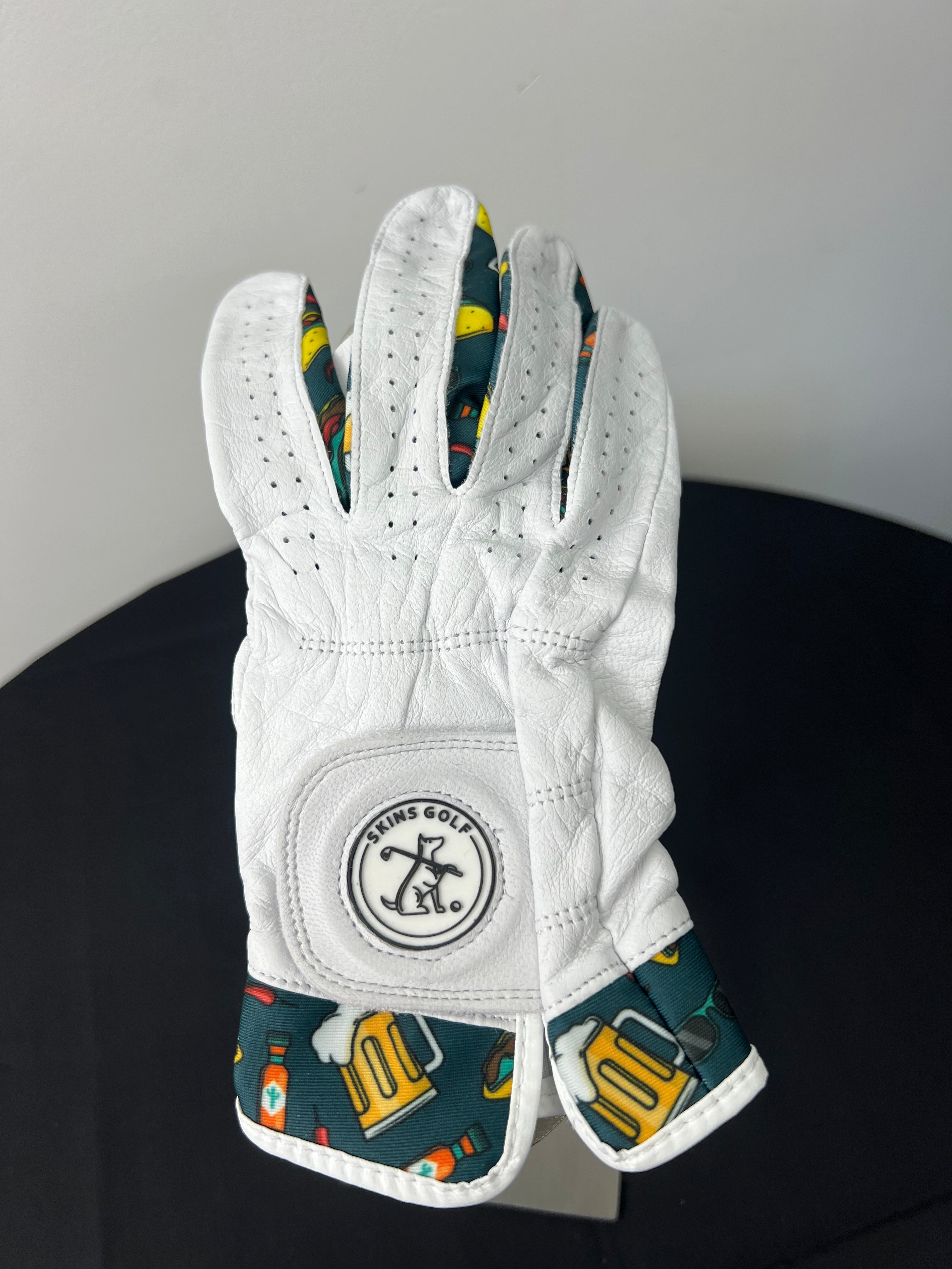 White women's golf glove with taco and beer print accents, logo visible