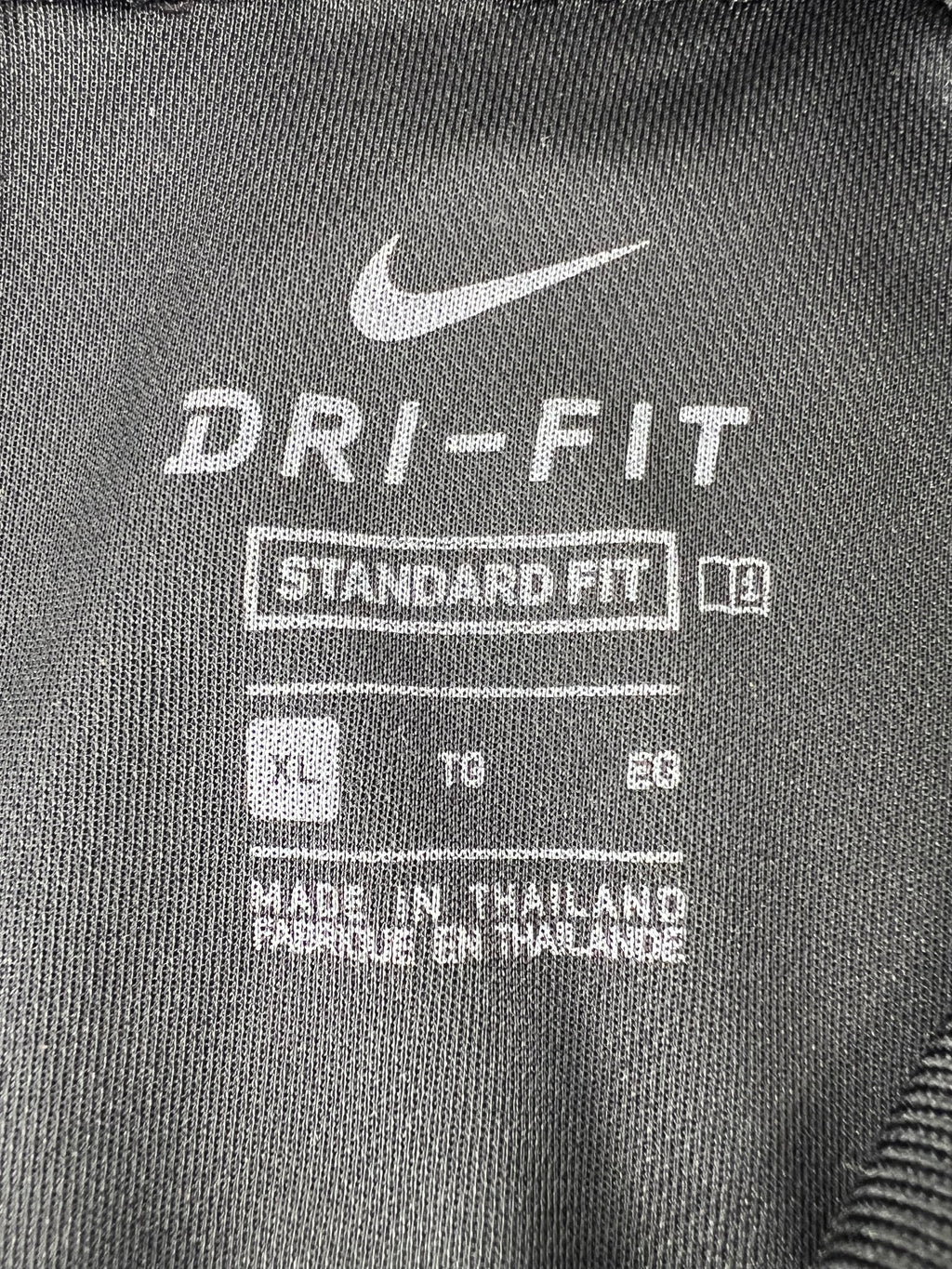 Close-up of Nike Dri-FIT XL label inside black golf polo shirt