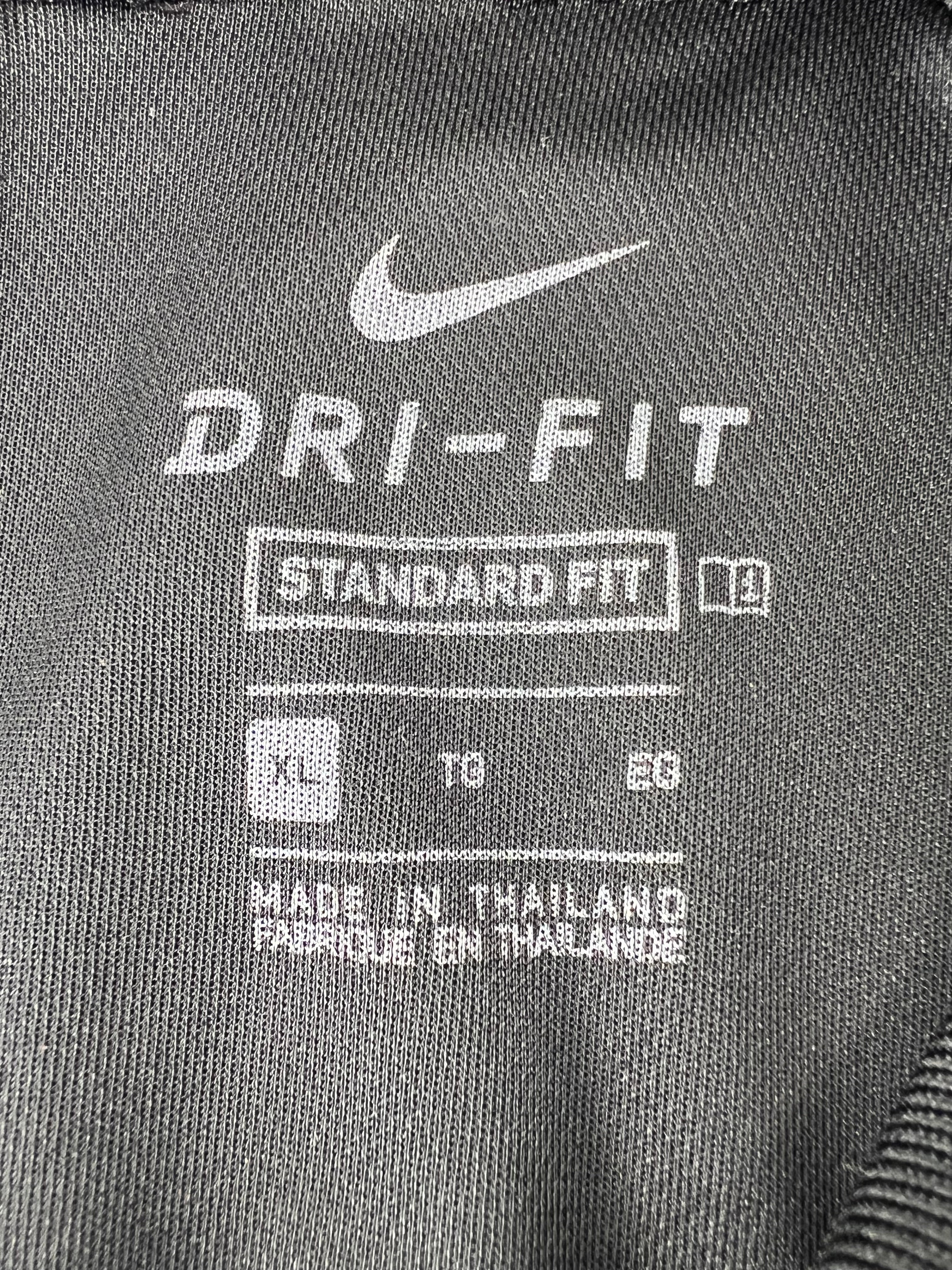 Close-up of Nike Dri-FIT XL label inside black golf polo shirt