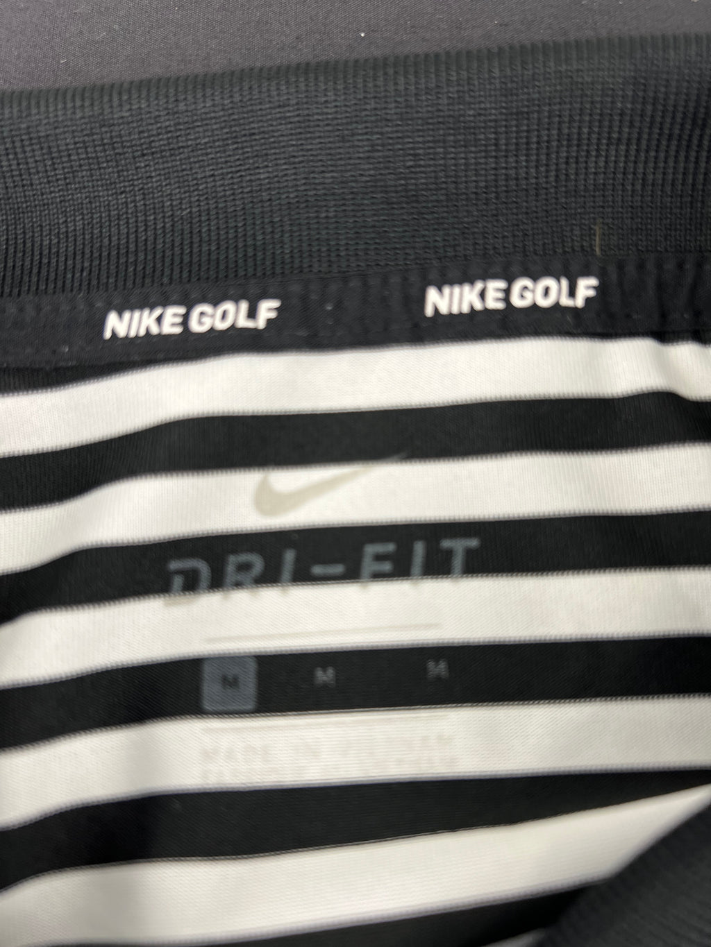 Close-up detail of Nike Golf Dri-FIT label inside the polo shirt