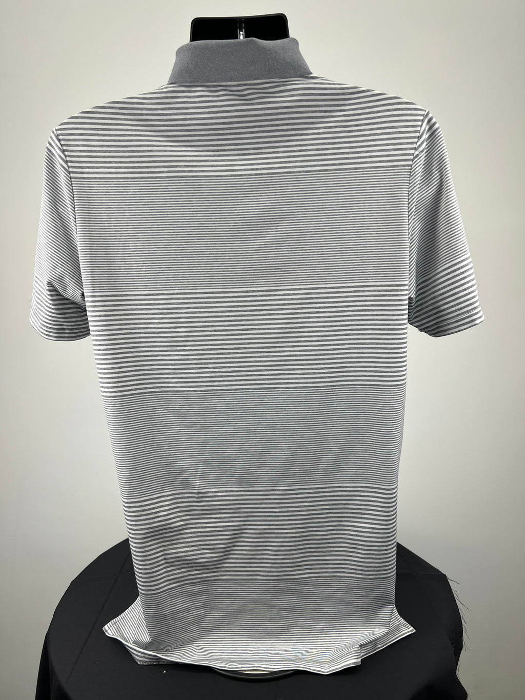 Back view of Ralph Lauren RLX grey and white striped polo shirt on mannequin