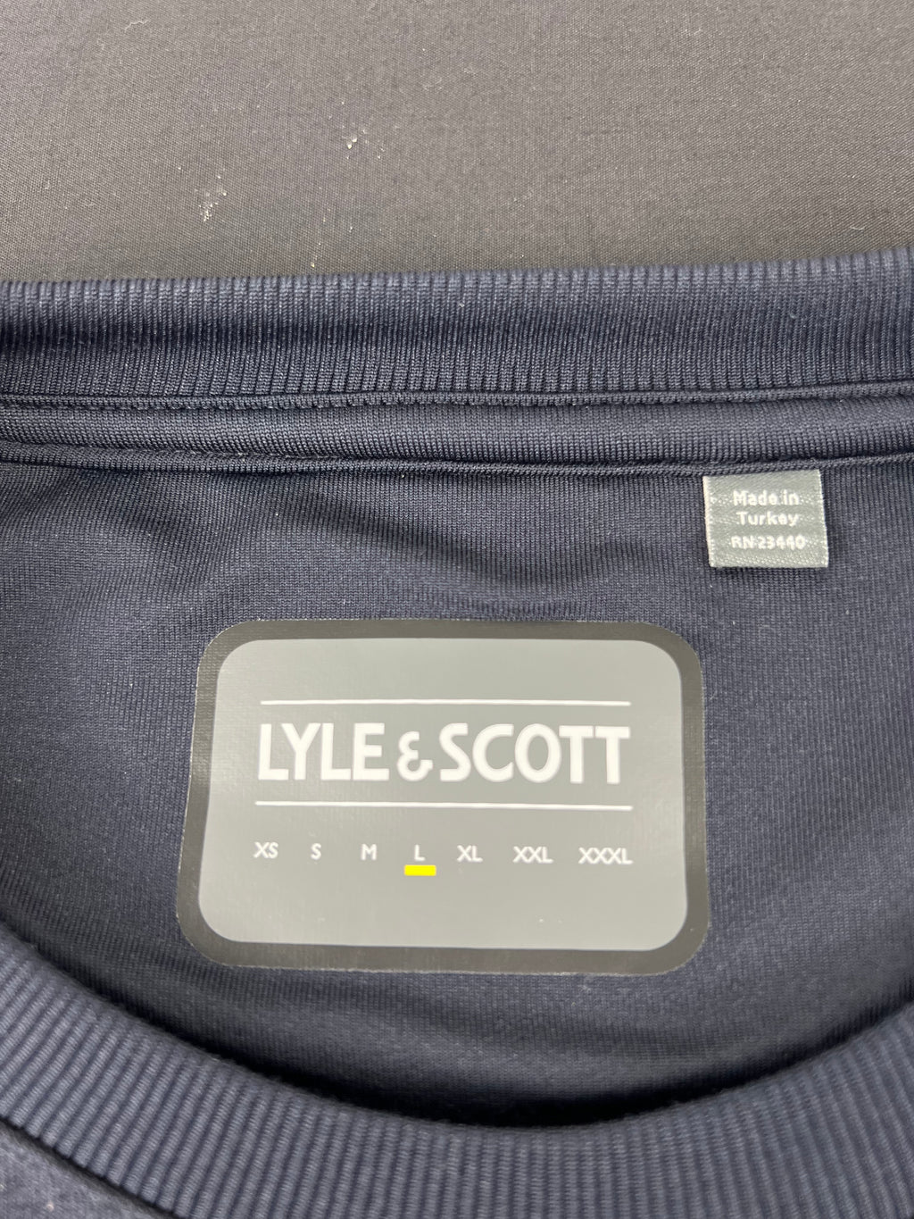 Close-up of Lyle and Scott label inside collar indicating size L and made in Turkey