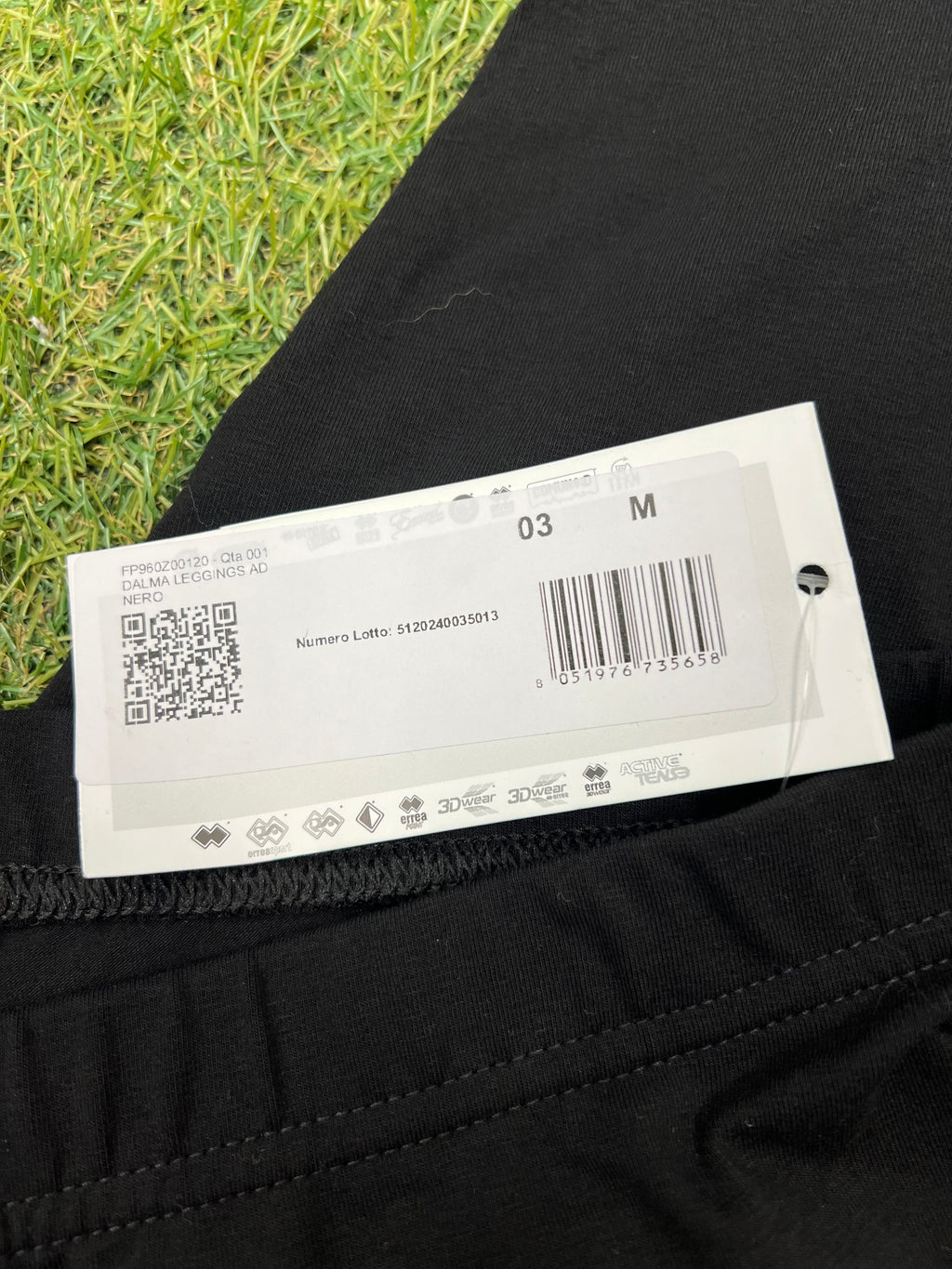 Close-up of product tag showing size medium and product code on black leggings