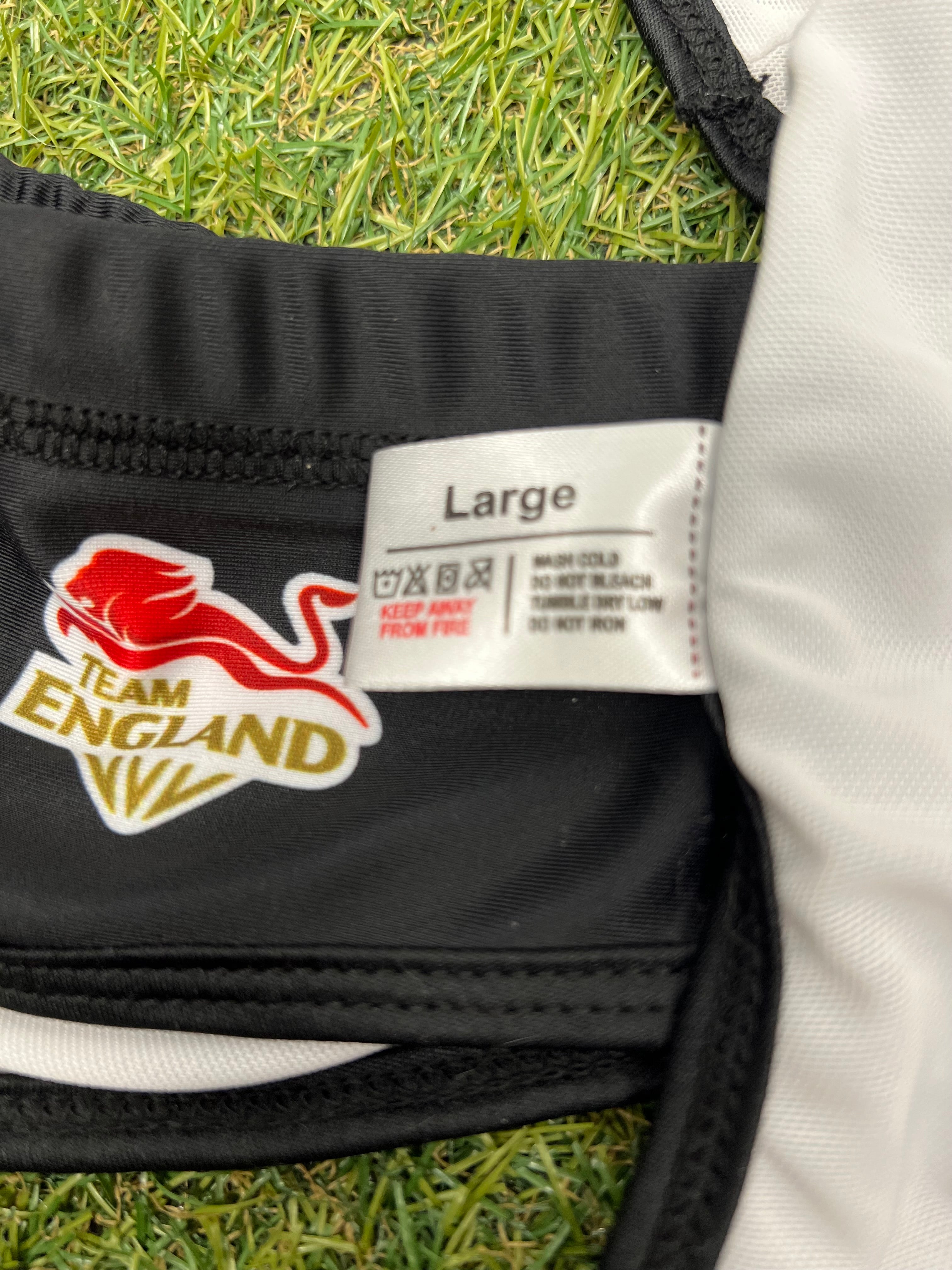 Close-up of Team England logo and large size tag on black volleyball bikini fabric
