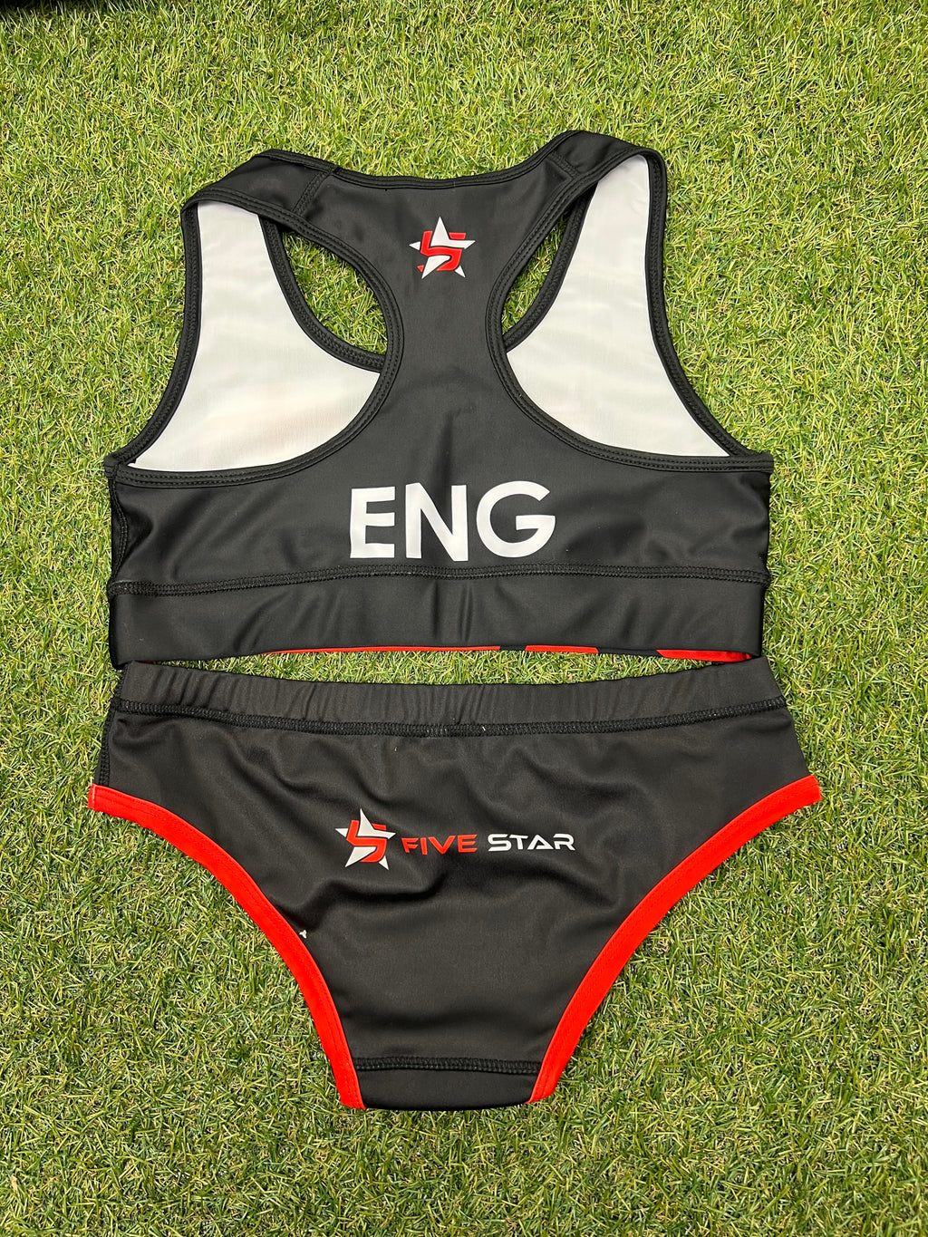 Back view of women’s Team England black and red beach volleyball bikini showing racerback design and logos