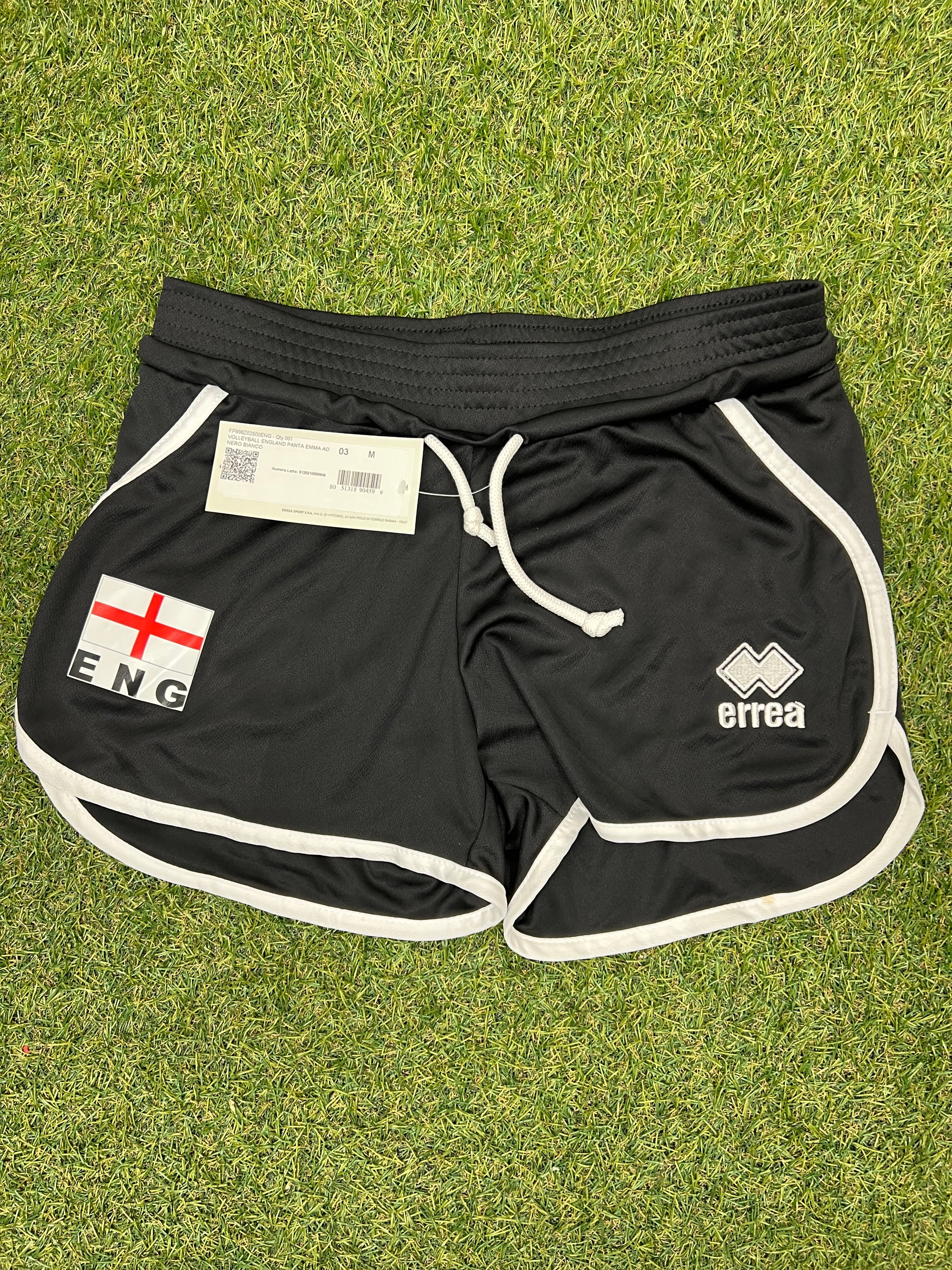 Front view of black women’s volleyball shorts with England flag patch and Erreà logo on grass
