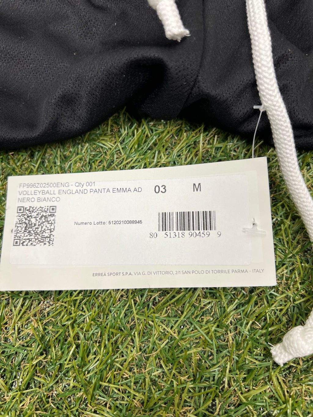 Close-up of product tag showing size M and volleyball England details