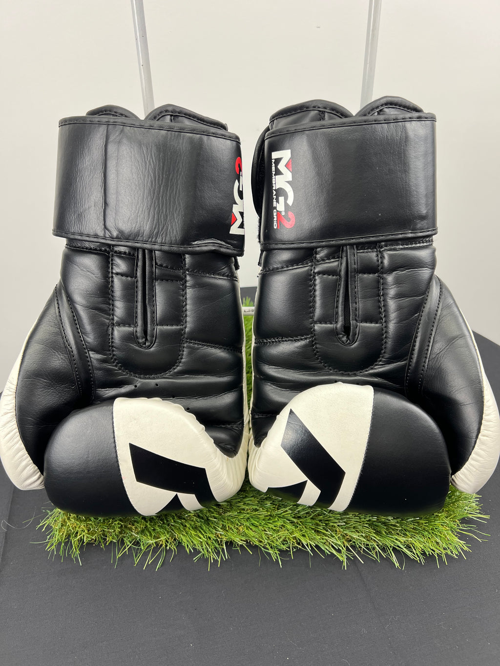 Rear view of RDX Safe-Tech 4 black and white boxing gloves showing padded design and wrist straps