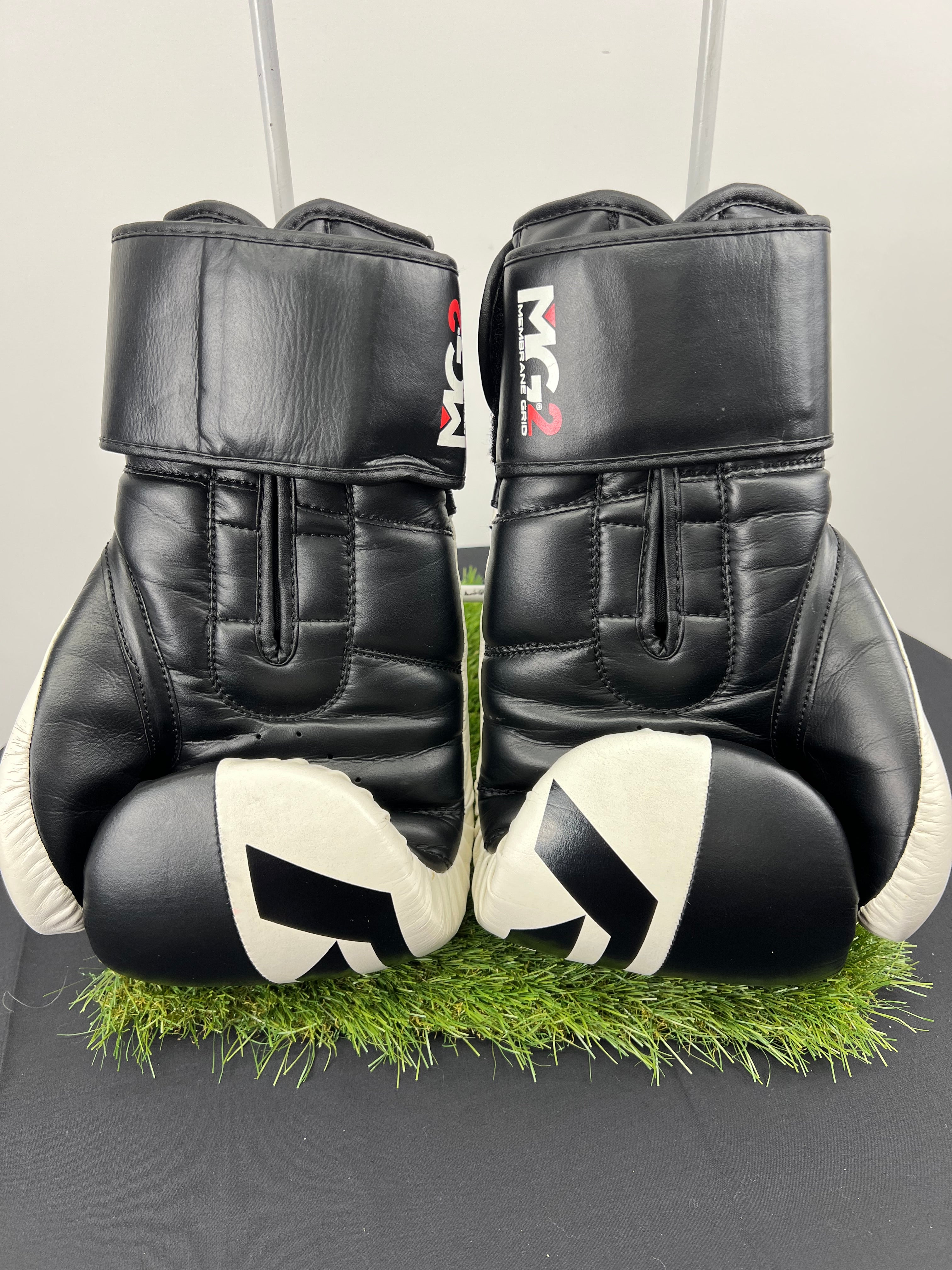 Rear view of RDX Safe-Tech 4 black and white boxing gloves showing padded design and wrist straps