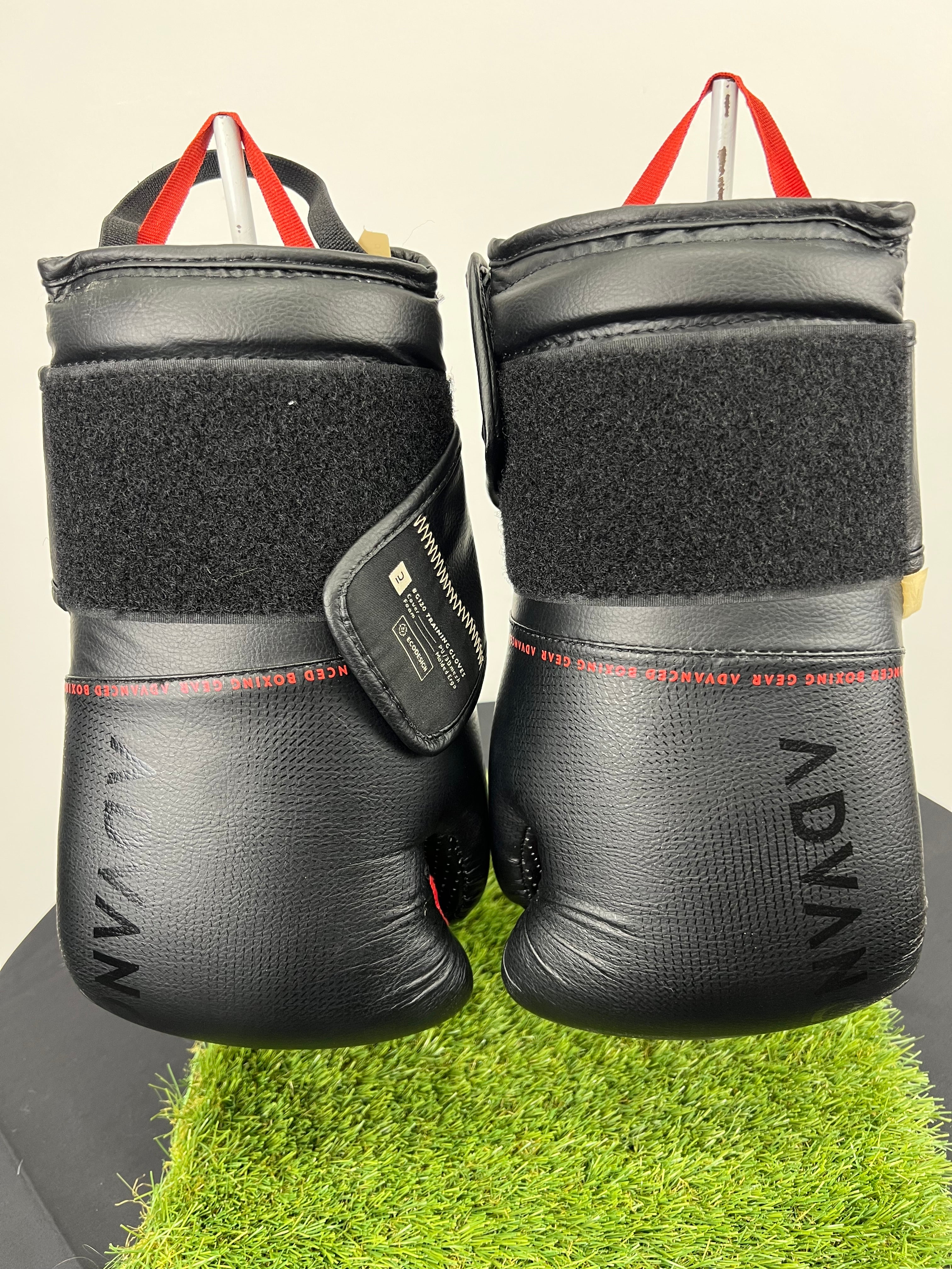 Front view of black Outshock boxing gloves with wide velcro straps and red hanging loops