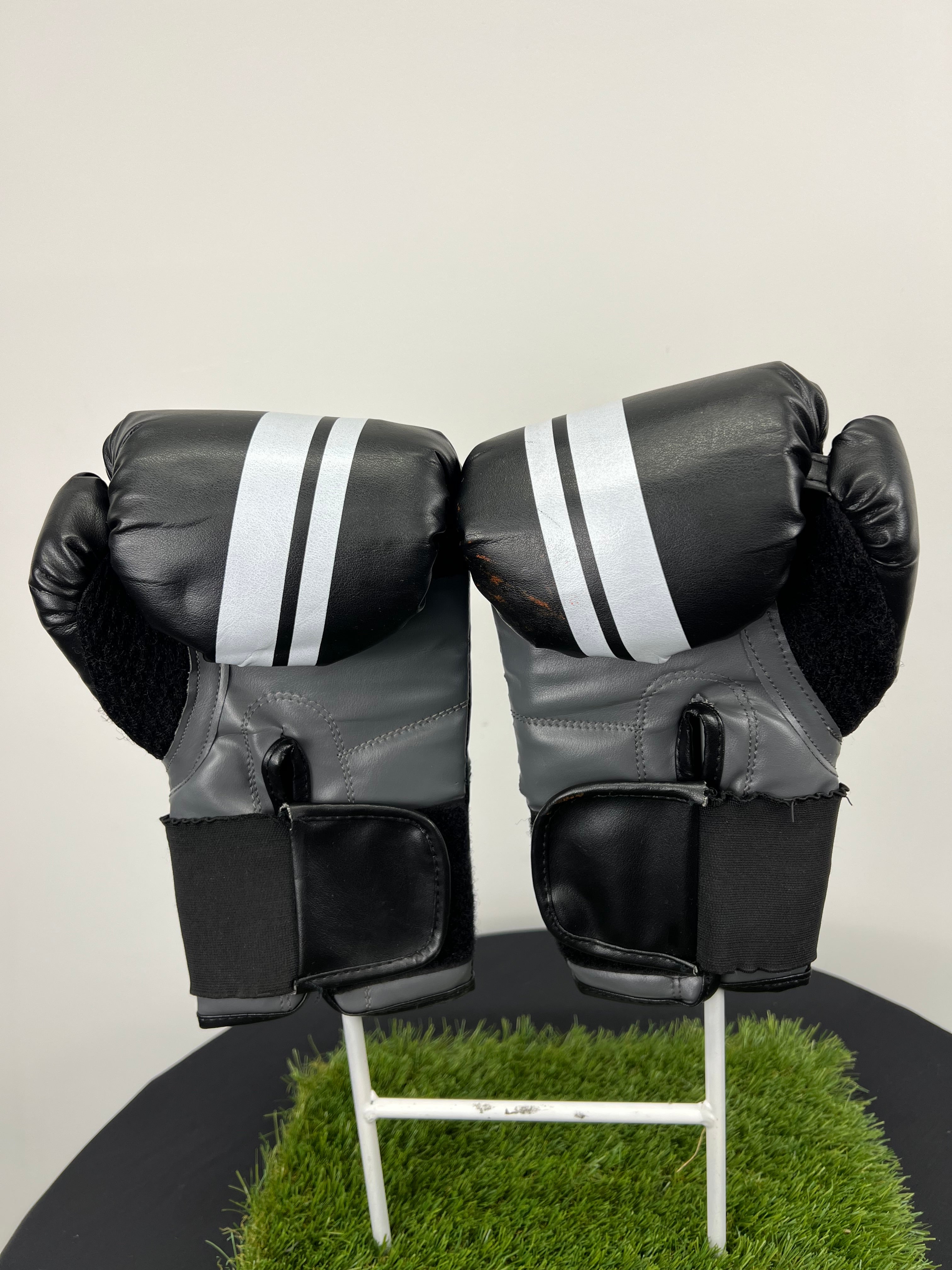 Back view of Lonsdale London black boxing gloves showing wrist straps and grey inner lining
