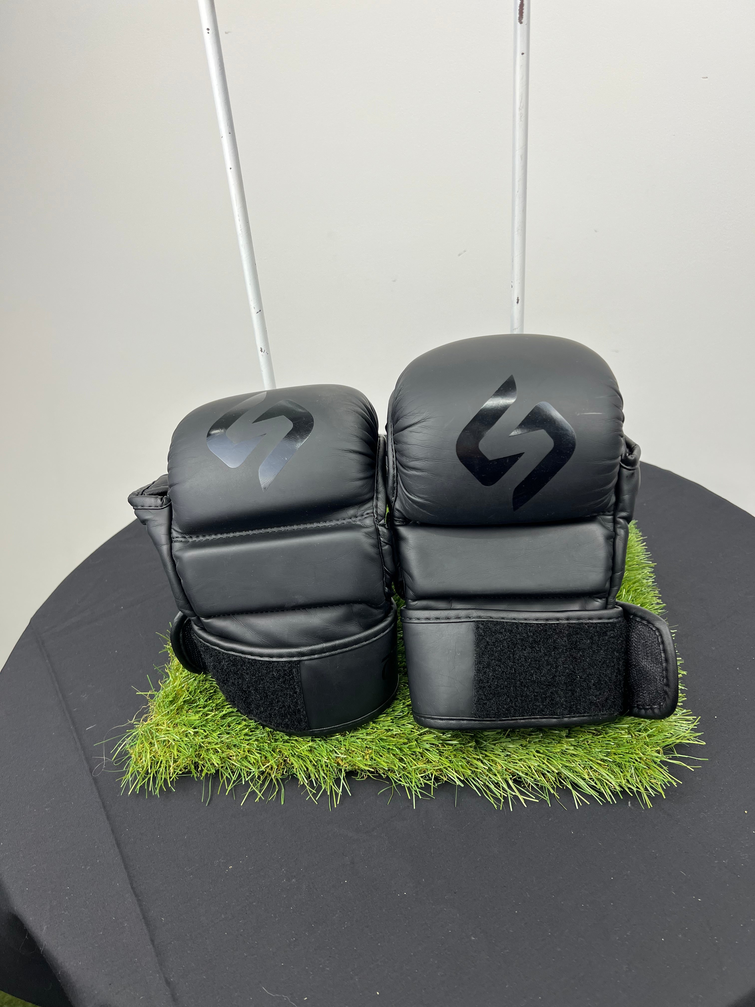 Front view of Sakuri Sport CB2 large size black grappling gloves with protective knuckle padding and wrist strap