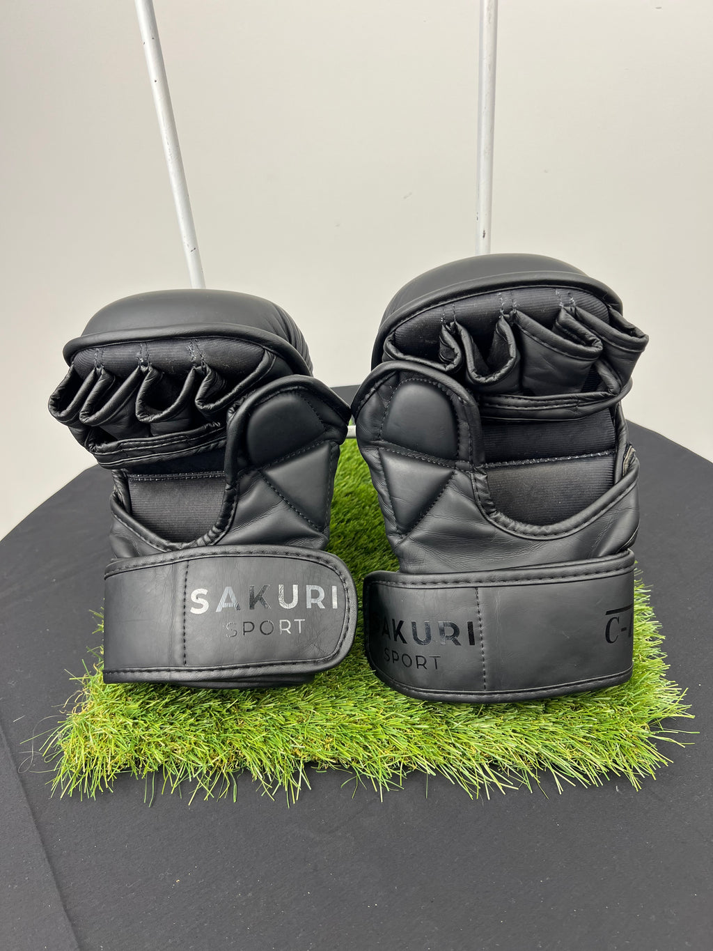 Rear view of Sakuri Sport CB2 large size black grappling gloves showing fingerless design and adjustable velcro wrist straps