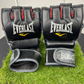 Everlast MMA grappling gloves in black with red finger accents, front view showing knuckle padding and wrist strap