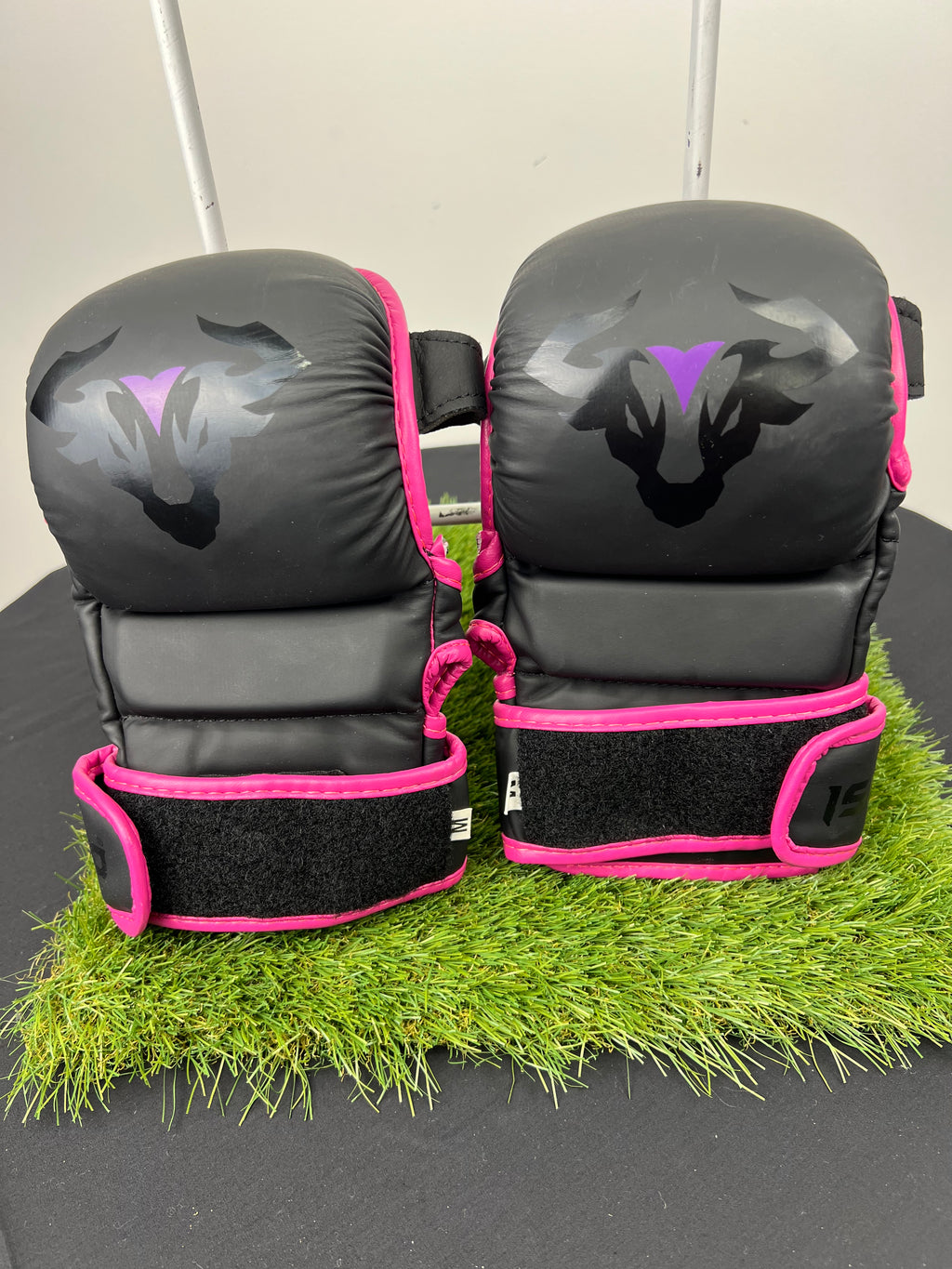 Front view of Islero MMA grappling gloves in black with pink trim and bull logo