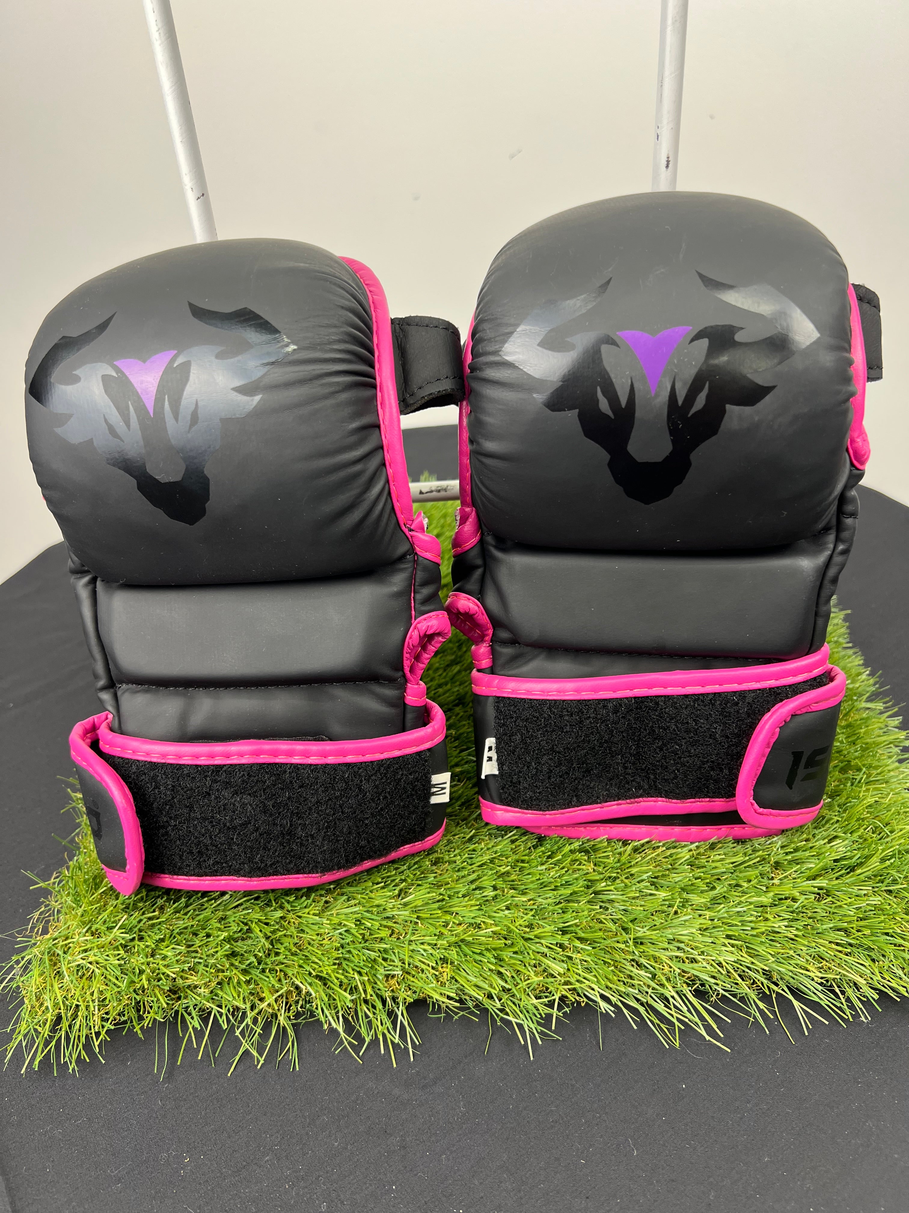 Front view of Islero MMA grappling gloves in black with pink trim and bull logo