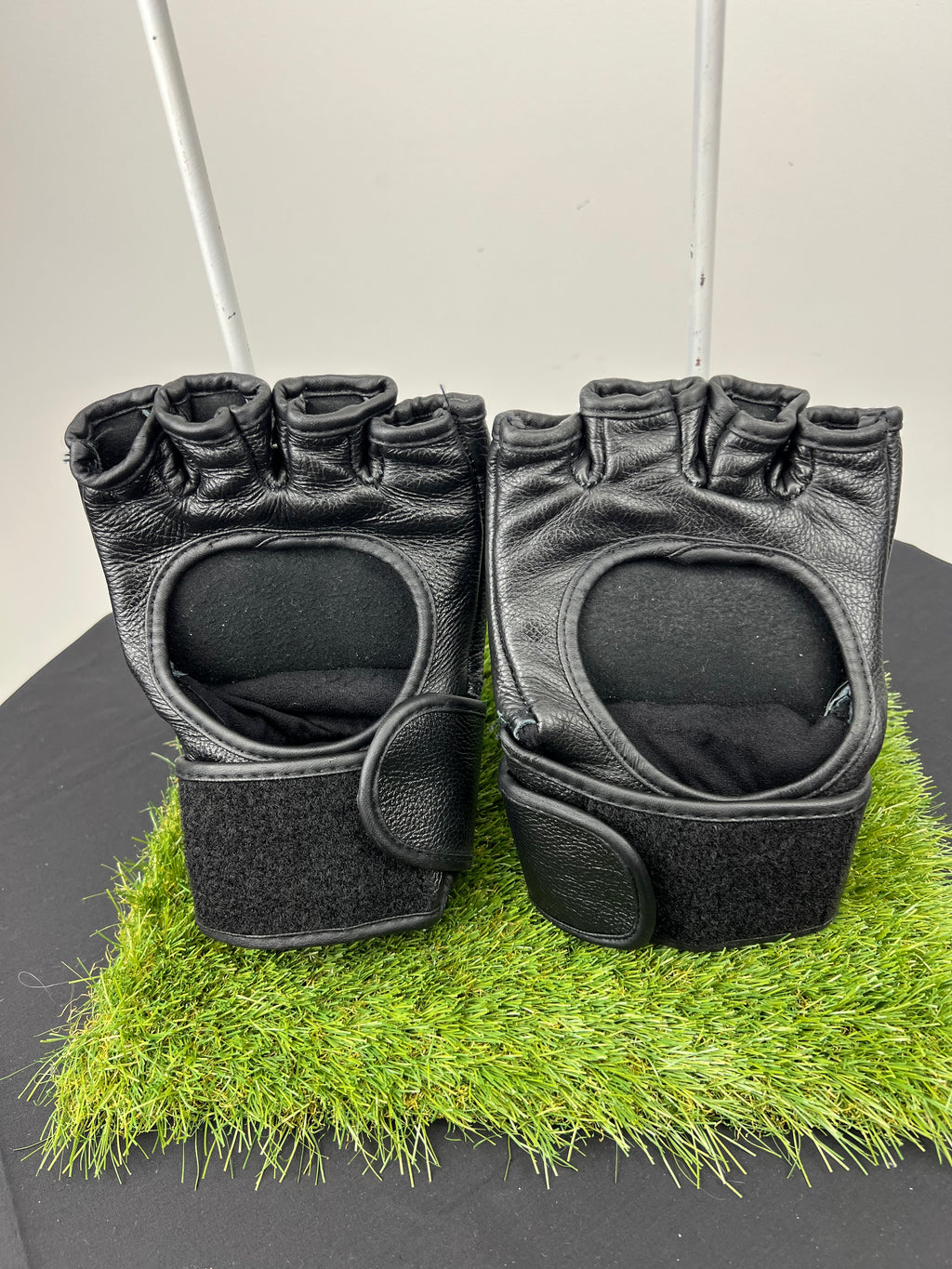 Pair of black Reebok open palm grappling gloves showing open palm design and Velcro wrist straps