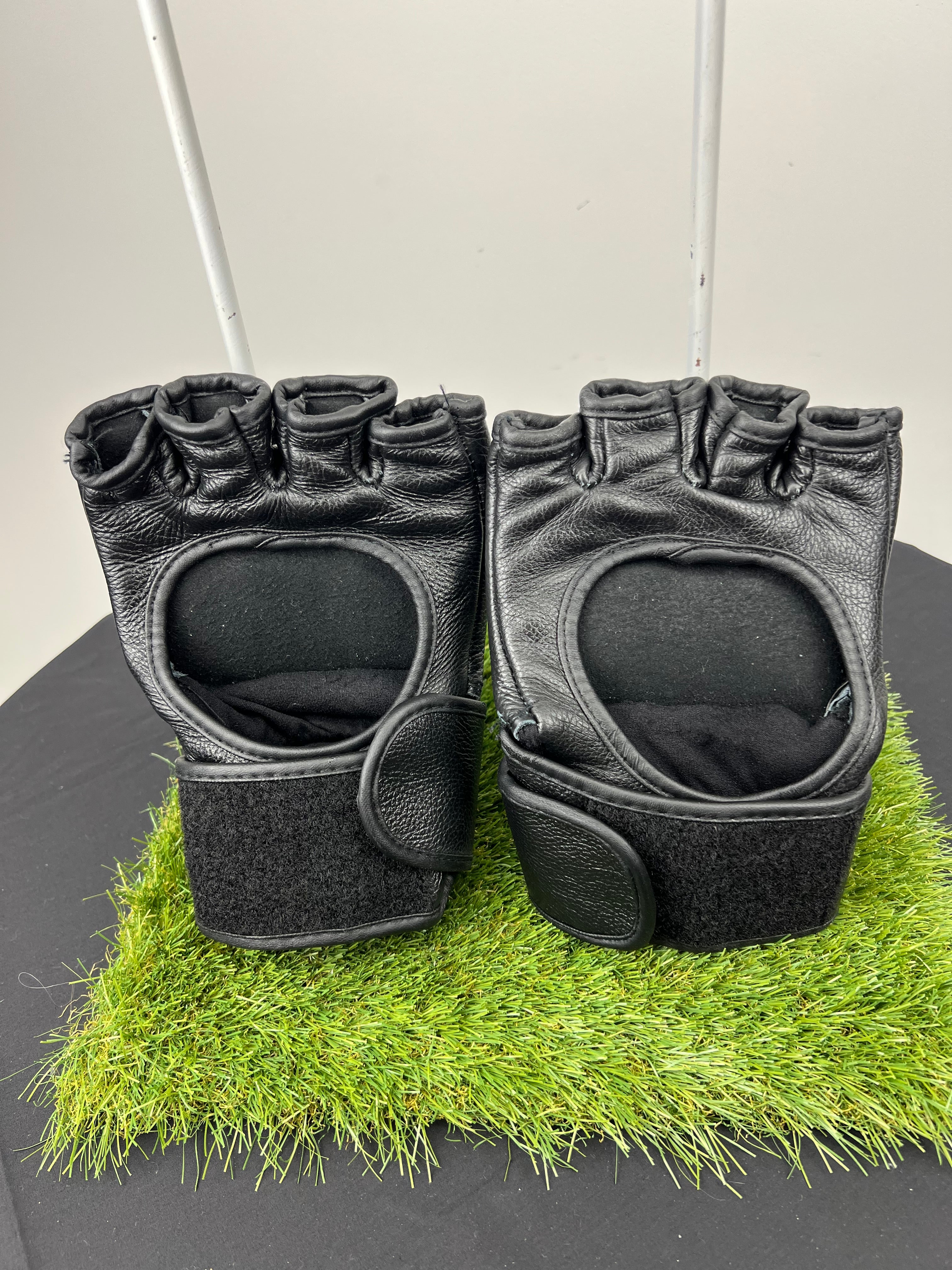 Pair of black Reebok open palm grappling gloves showing open palm design and Velcro wrist straps