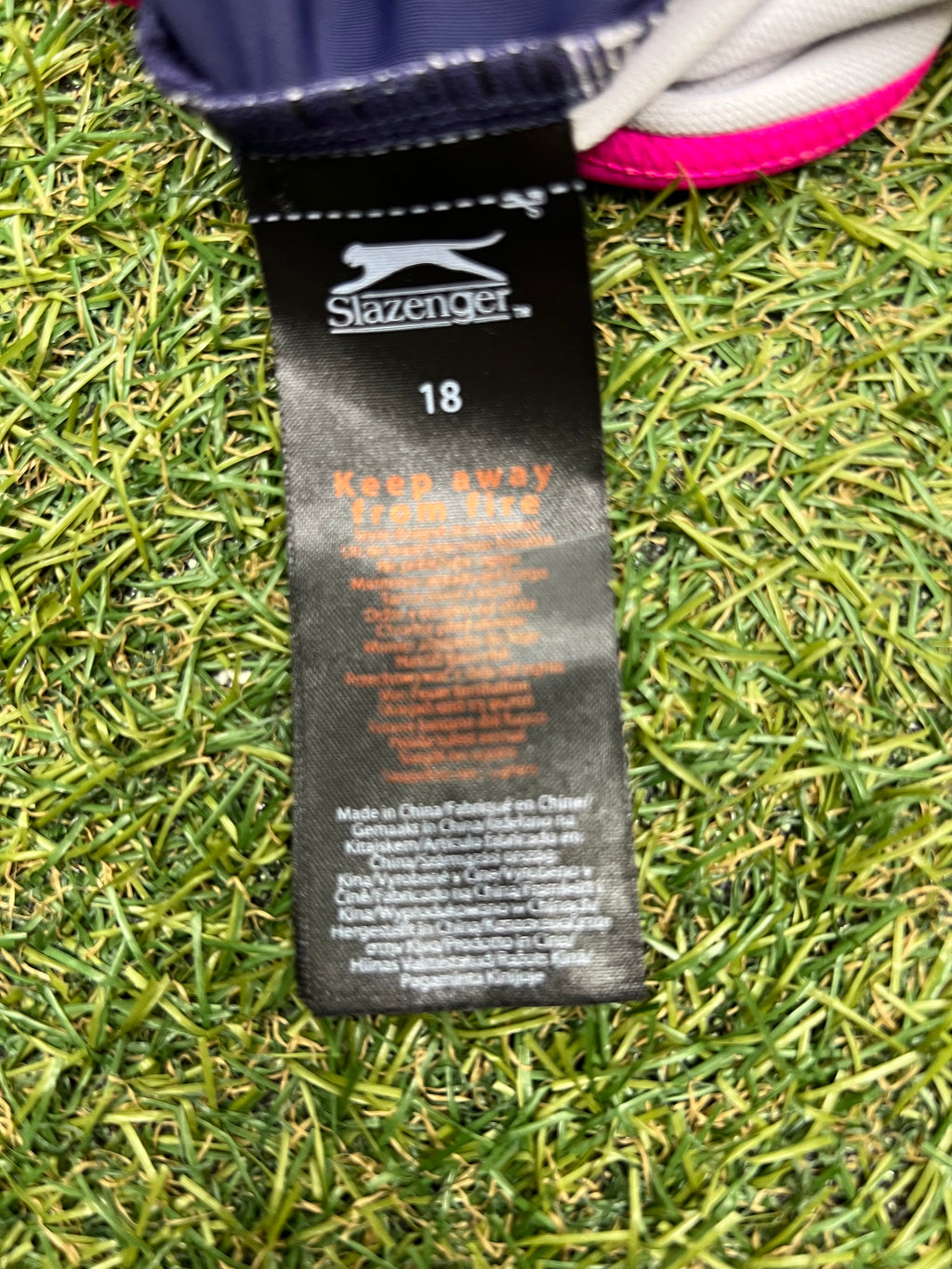 Close-up image of size and care label inside women's Slazenger swimsuit indicating size 18 and care instructions