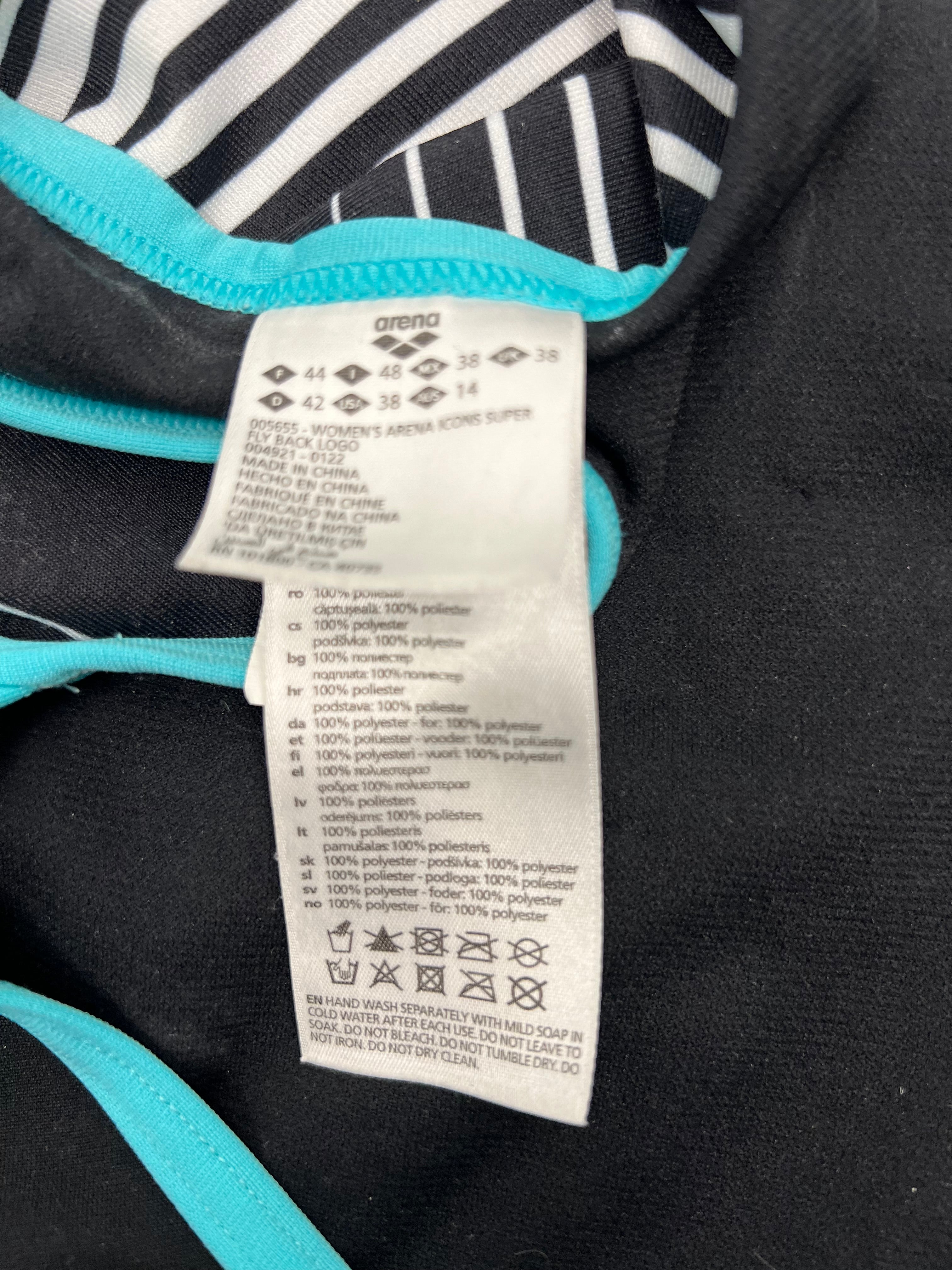 Close-up of fabric tag showing arena brand and 100% polyester material details inside the swimsuit