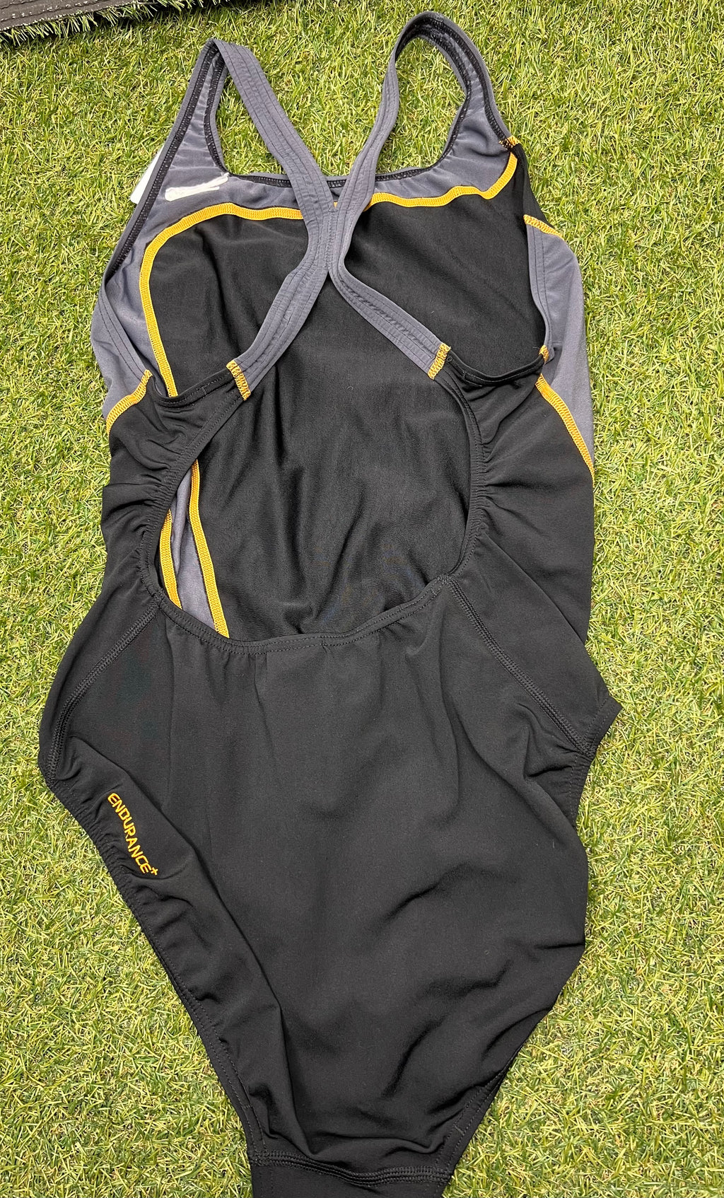 Back view of Speedo women's black and grey swimsuit showing crossed straps and Endurance+ logo