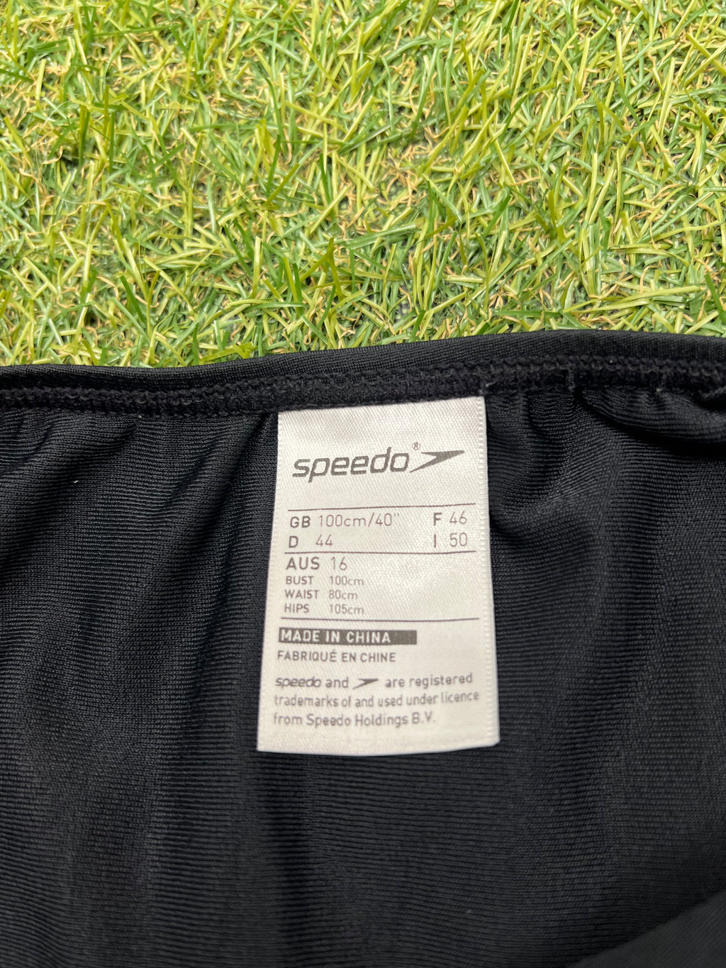 Close-up of Speedo swimsuit label indicating size 16 and measurements, made in China