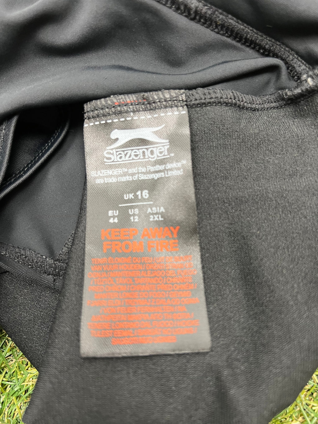 Close-up of Slazenger label and size information inside the black swimsuit