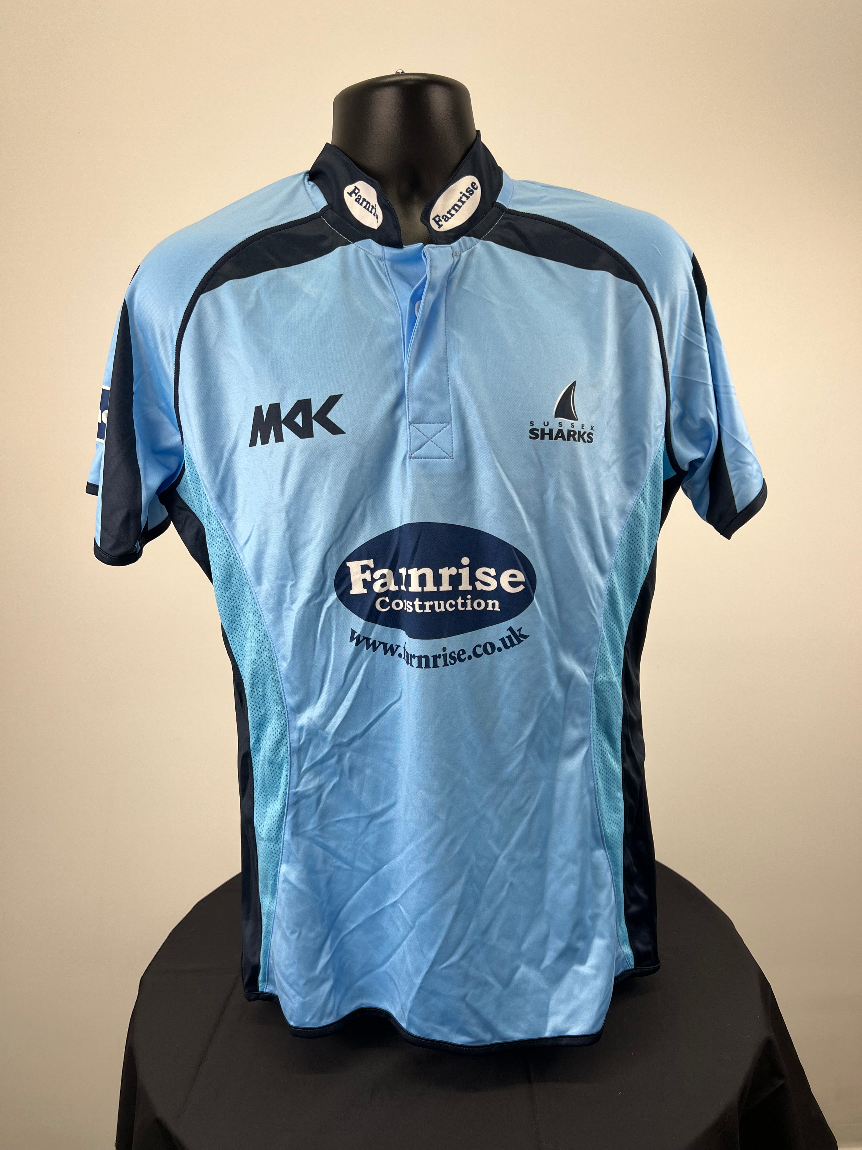 Front view of Sussex Sharks light blue cricket shirt with dark navy accents and Farnrise Construction logo