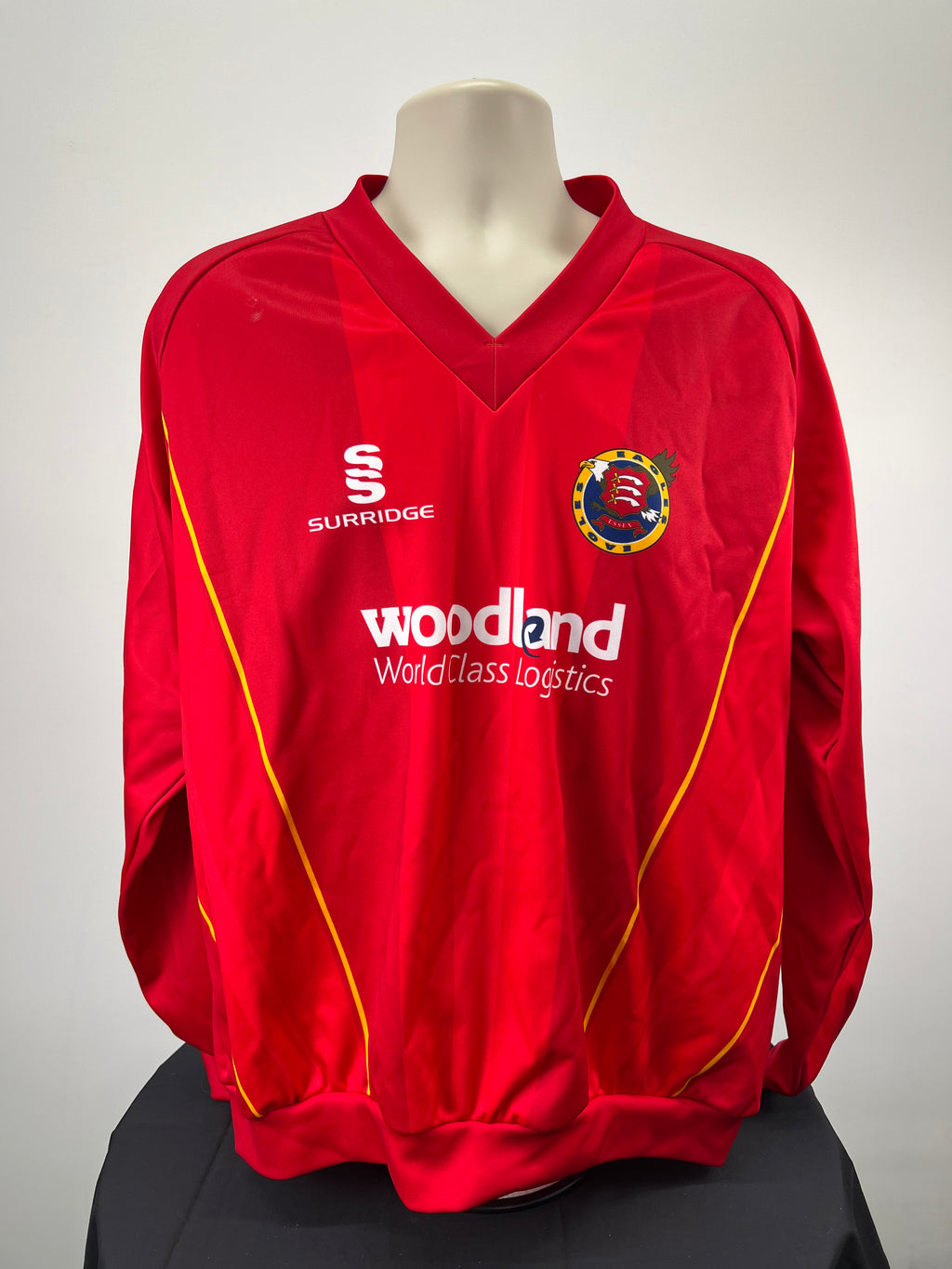 Front view of red Essex Eagles long sleeve cricket jumper with yellow piping and team crest