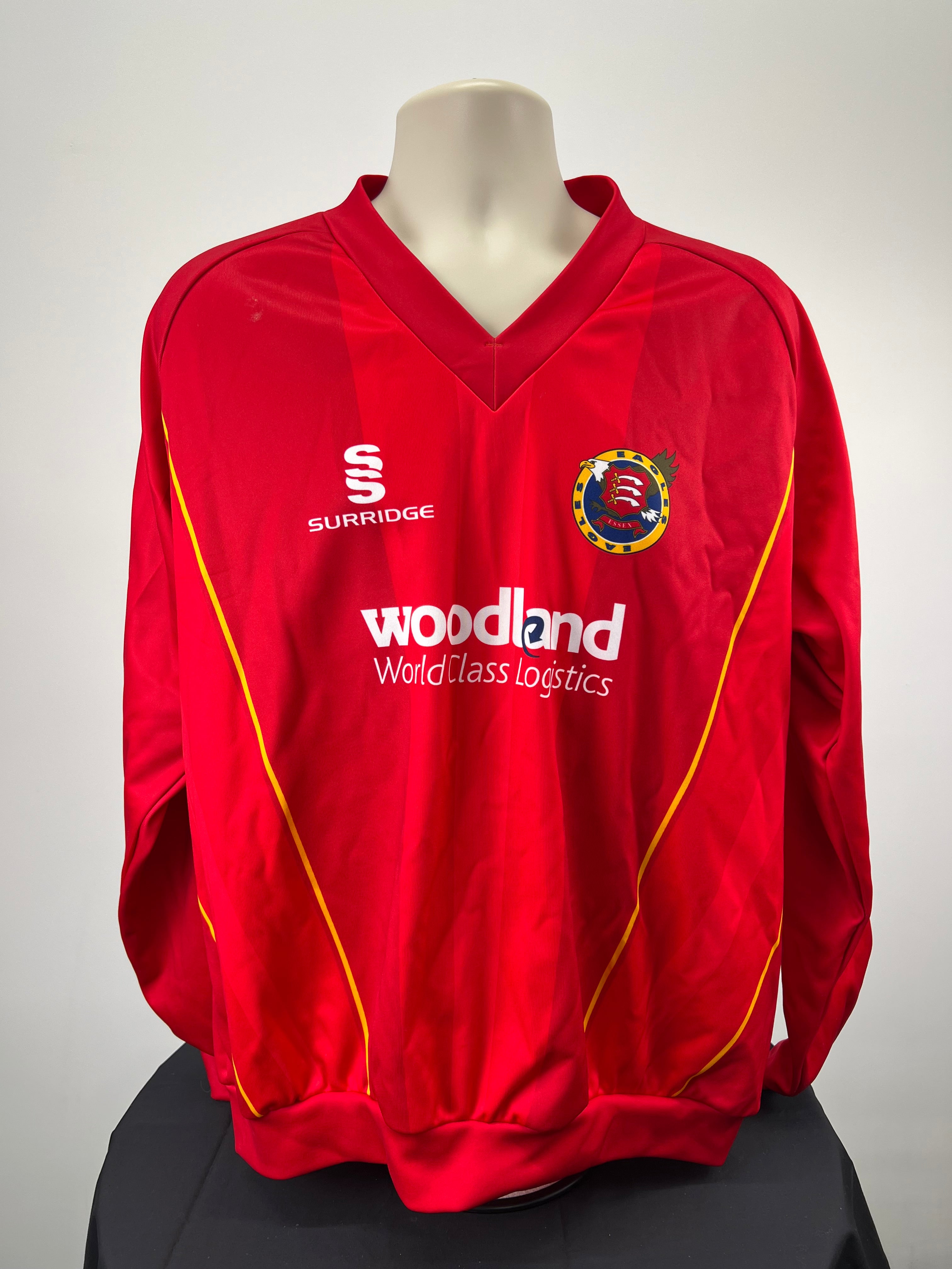 Front view of red Essex Eagles long sleeve cricket jumper with yellow piping and team crest