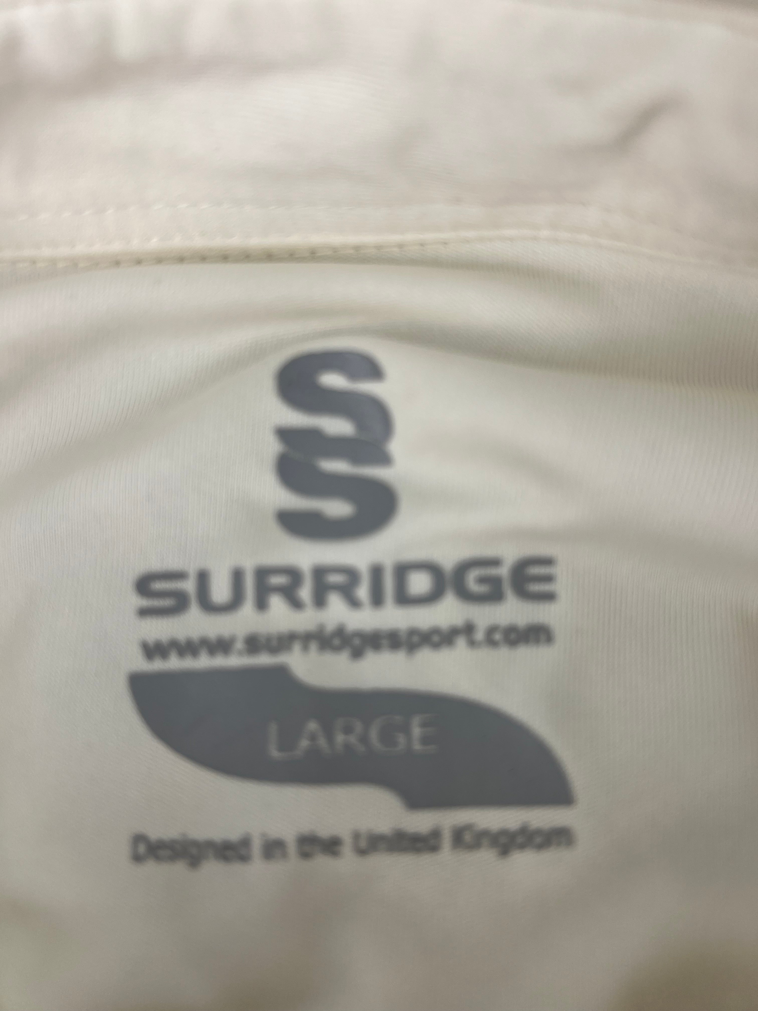 Close-up of Surridge brand label inside the cricket shirt showing size Large