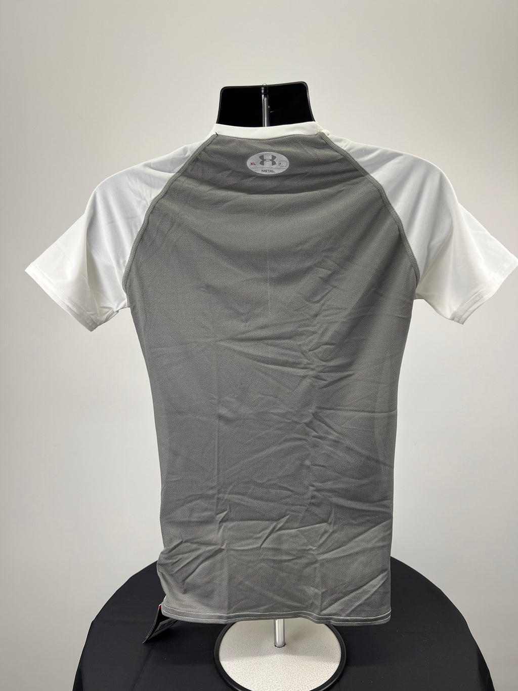 Back view of Under Armour Metal T-shirt showing grey mesh panel on back with logo at neck