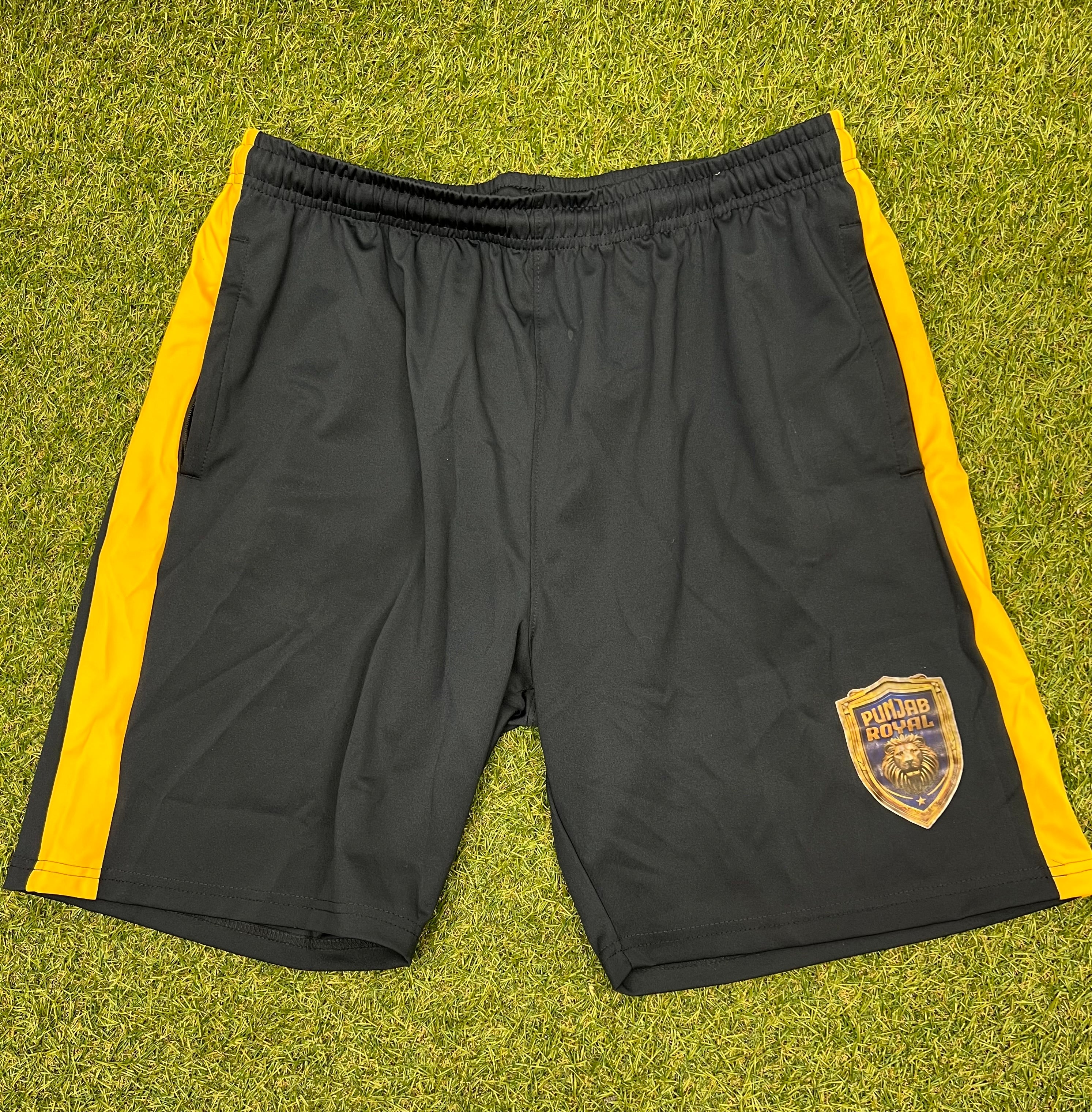 Front view of Men’s Punjab Royal black sports shorts with golden yellow side stripes and team lion logo