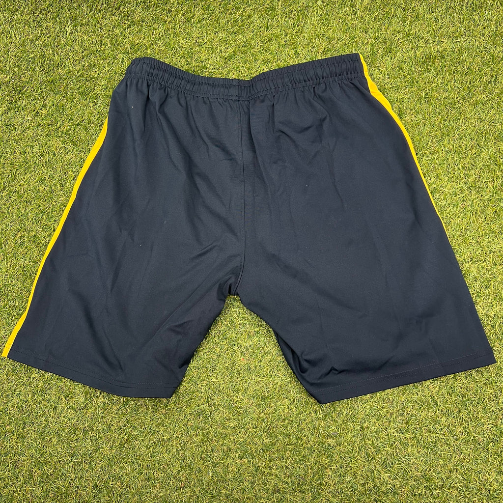 Back view showing plain black sports shorts with golden yellow side stripes and elastic waistband